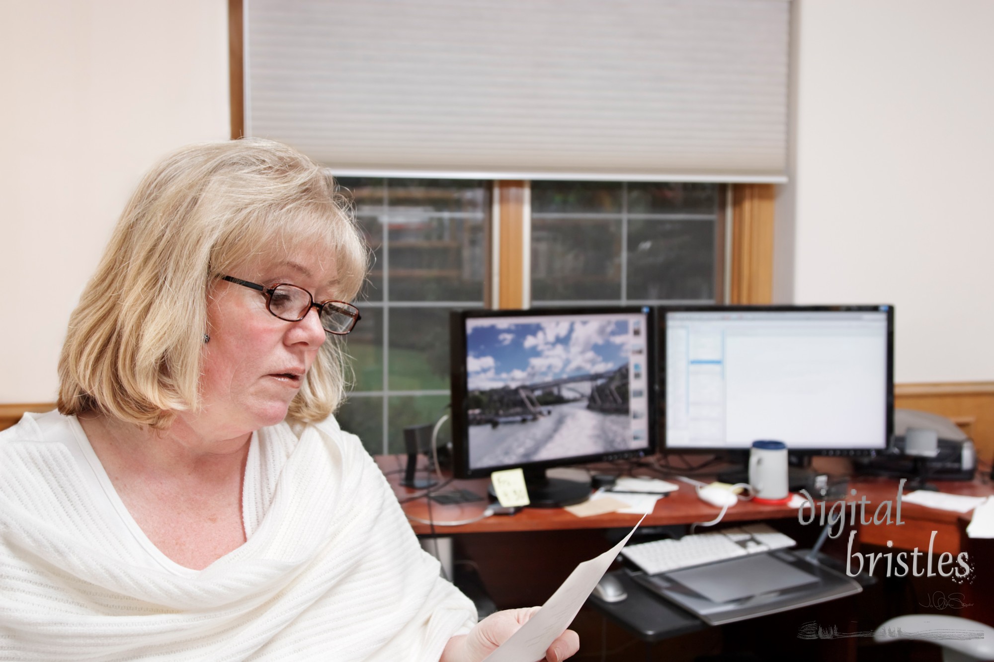 Mature woman reading and on the phone in a home office