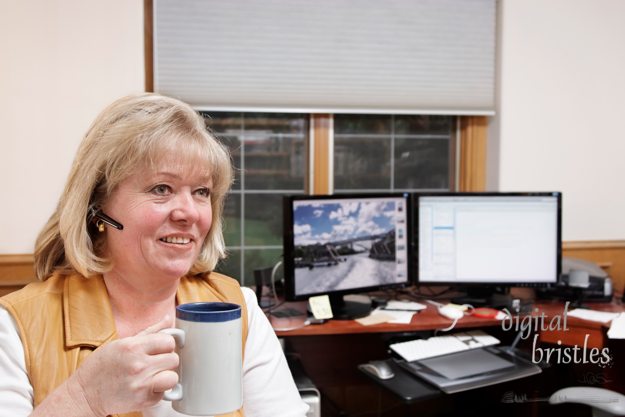 Mature woman on the phone with a coffee/tea mug in a home office