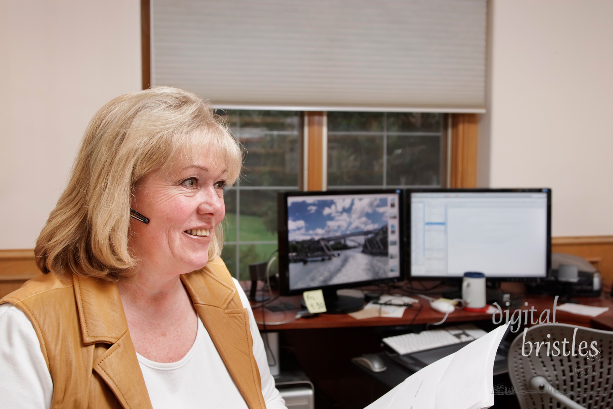 Mature woman smiles while on the phone in a home office