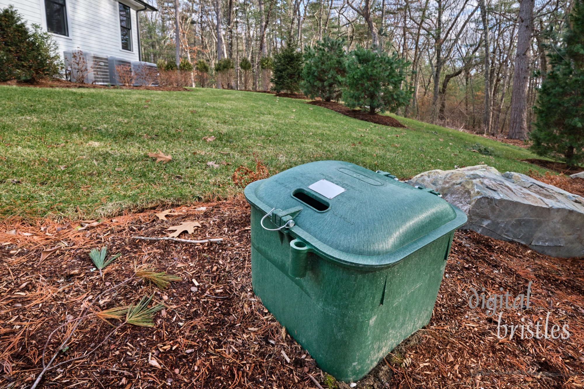 Underground propane tank  dome in the front flowerbed of a suburban home