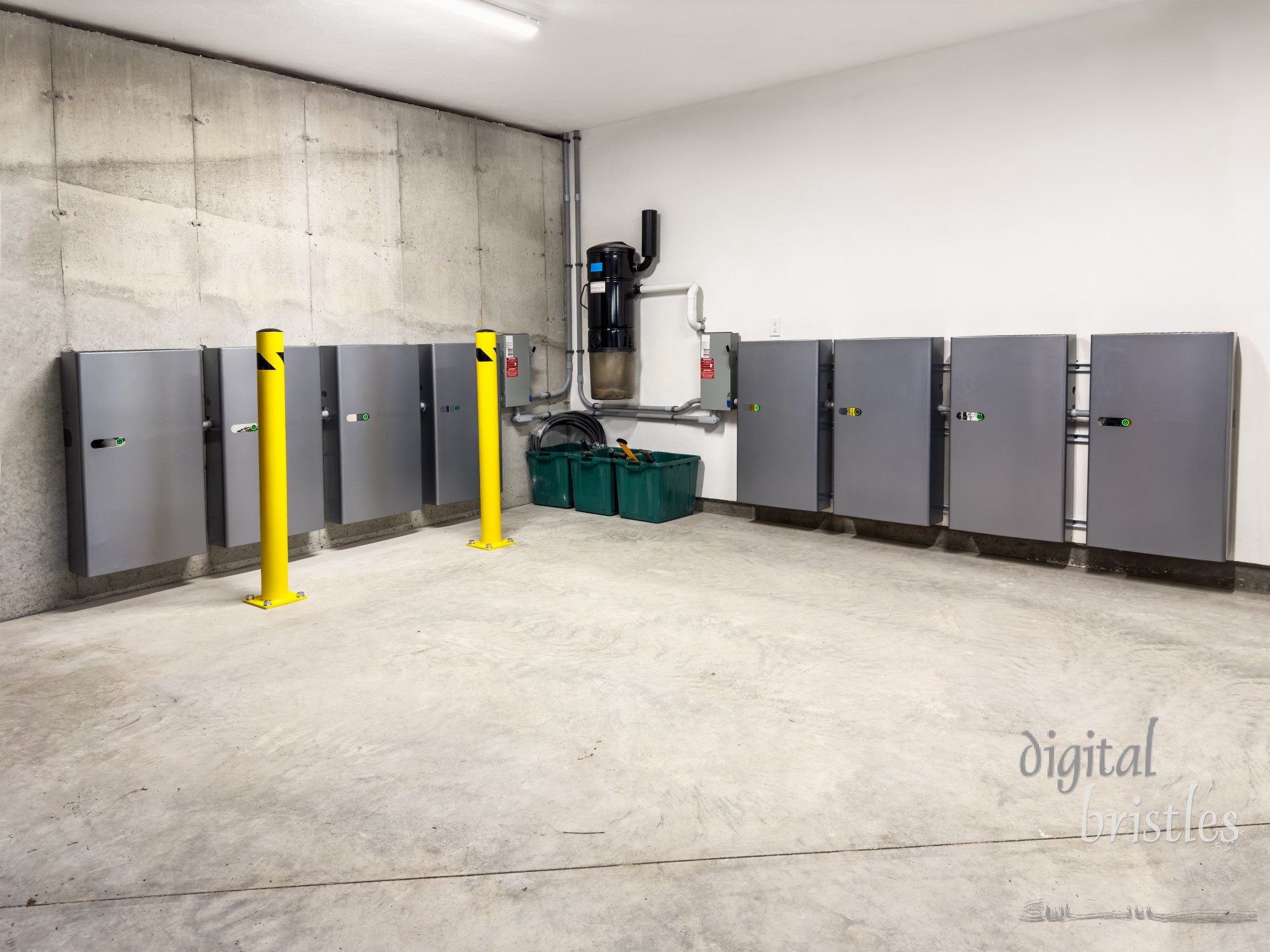 Storage batteries for solar power system installed on garage wall. Bollards protect from collisions