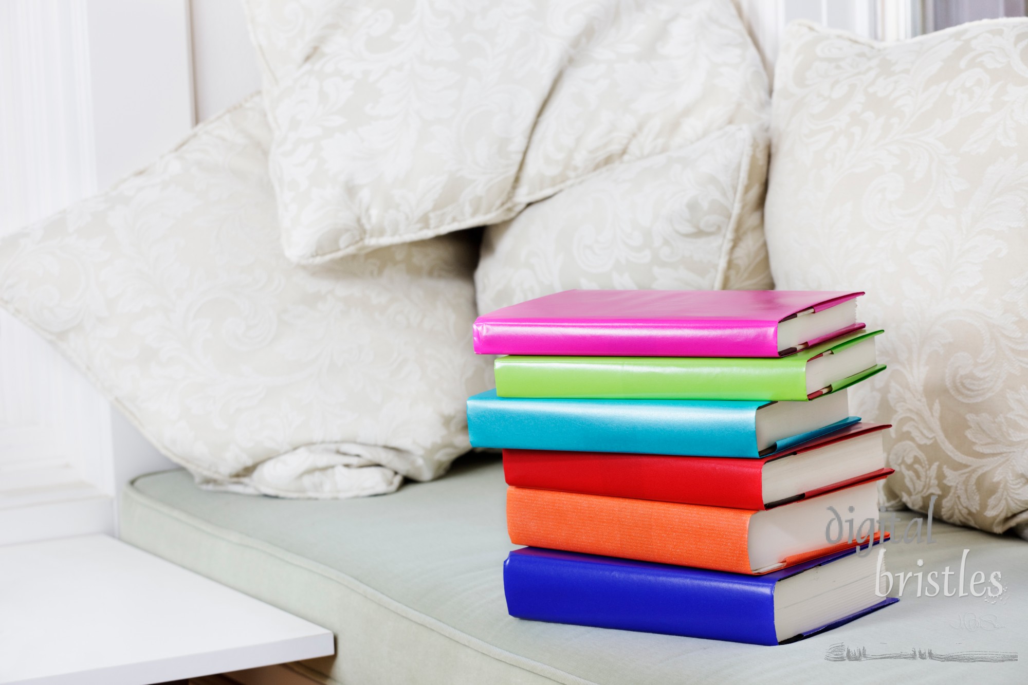 Window seat with cushions and a pile of books