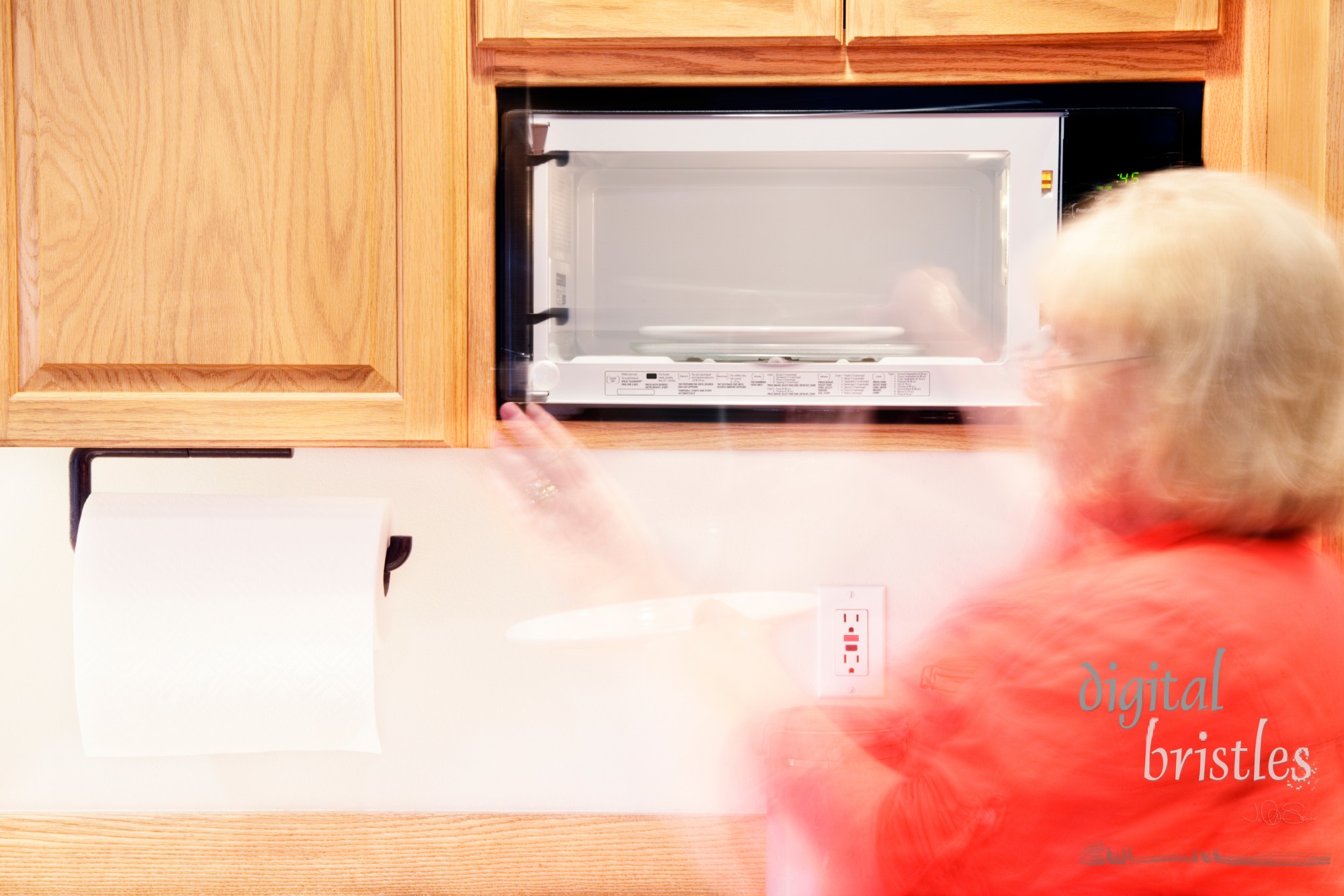 Woman busily moving about - putting something into the microwave