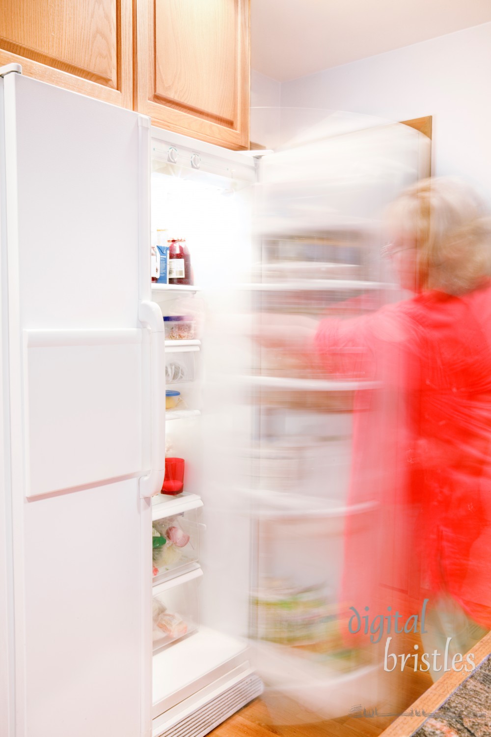 Woman busily moving about - getting things out of the refrigerator