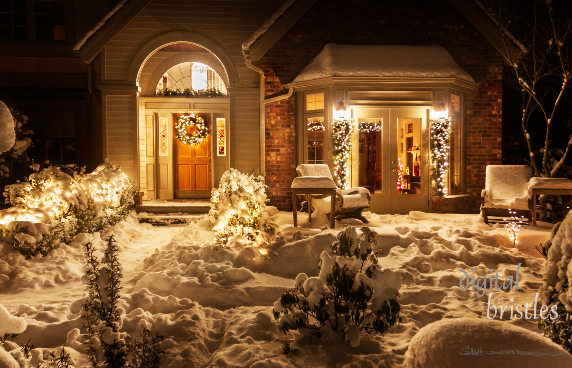 Outside lights brighten the snowy entrance to suburban home decorated for Christmas