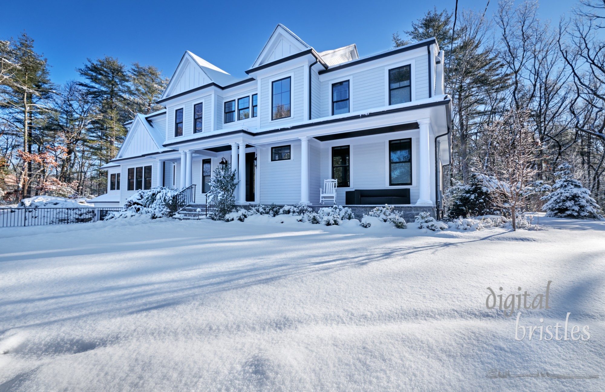 Suburban home on a sunny Winter morning after a snowstorm. Path and steps have been cleared