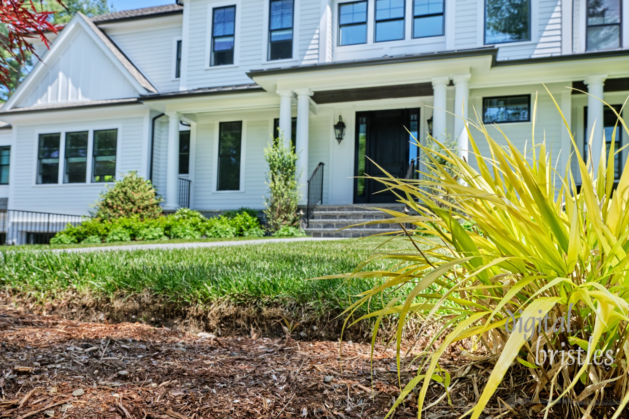 Spring garden cleanup in a suburban home - flowerbeds weeded and mulched and a sunny ornamental grass