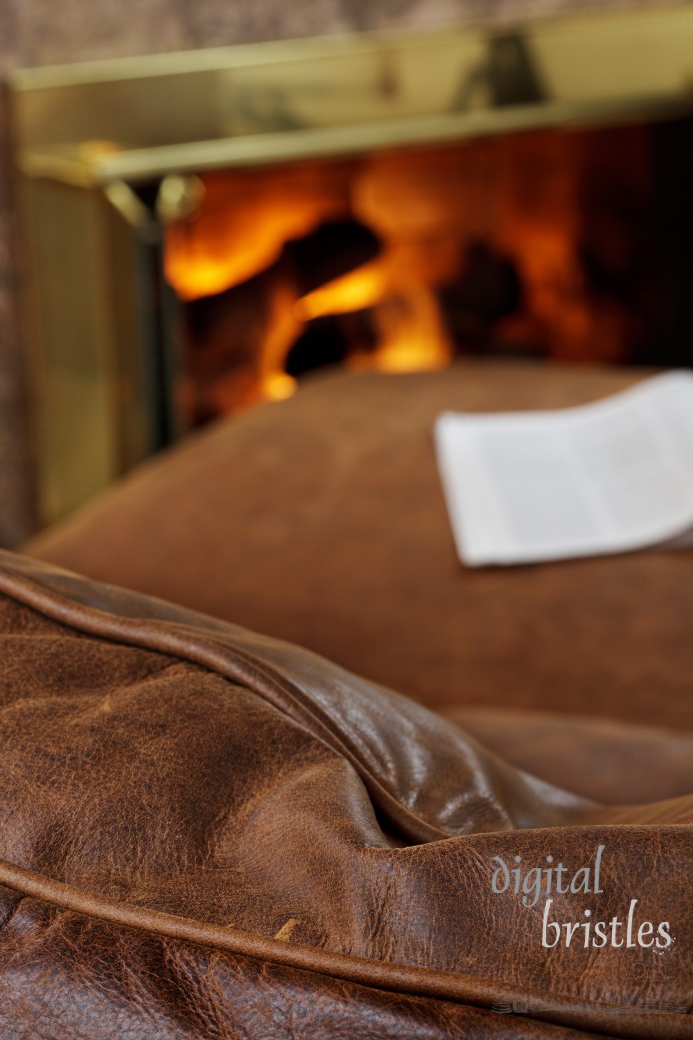 Magazine sits on leather ottoman by the fire