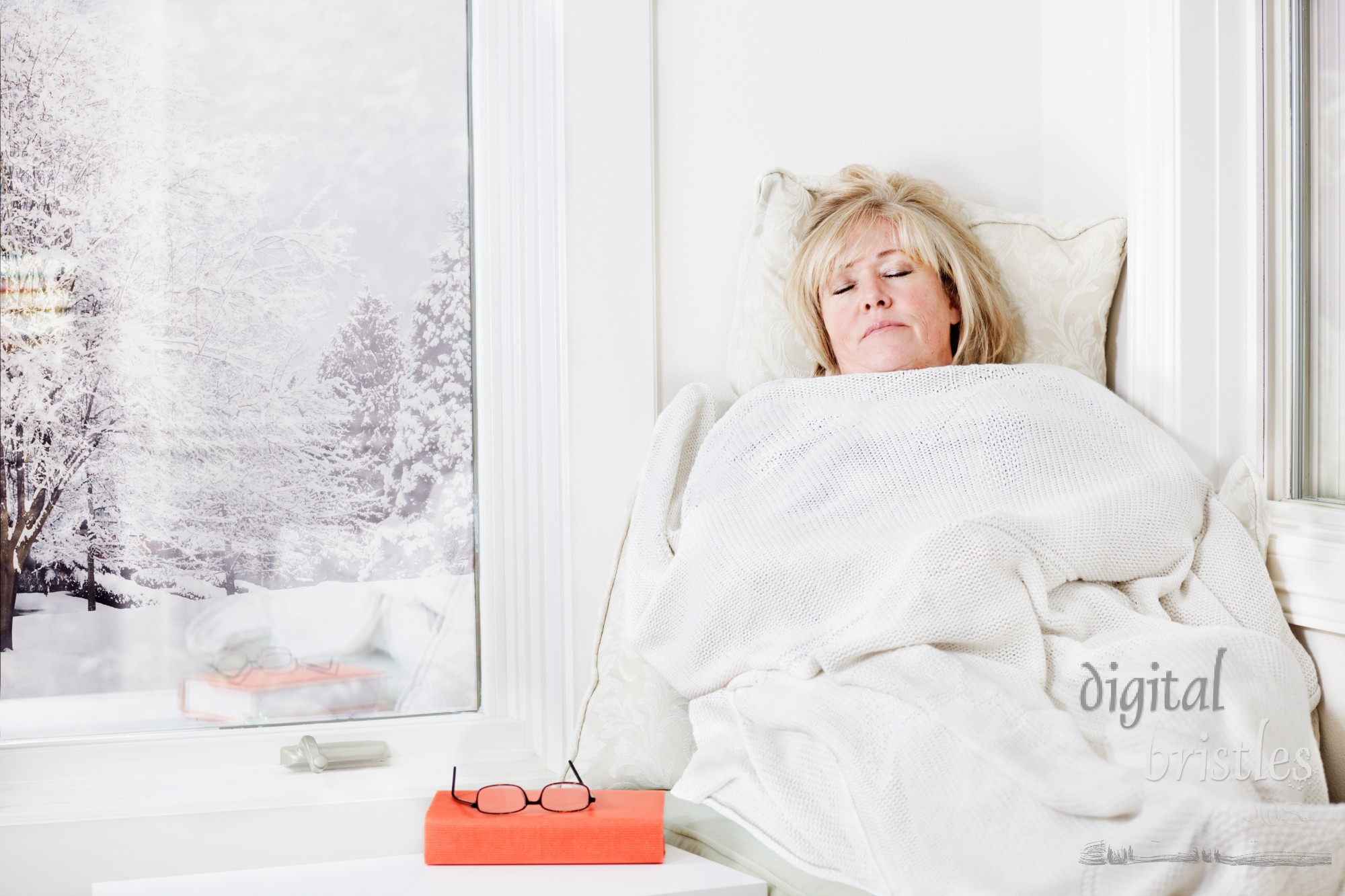 Mature woman lying down taking a nap under a warm blanket