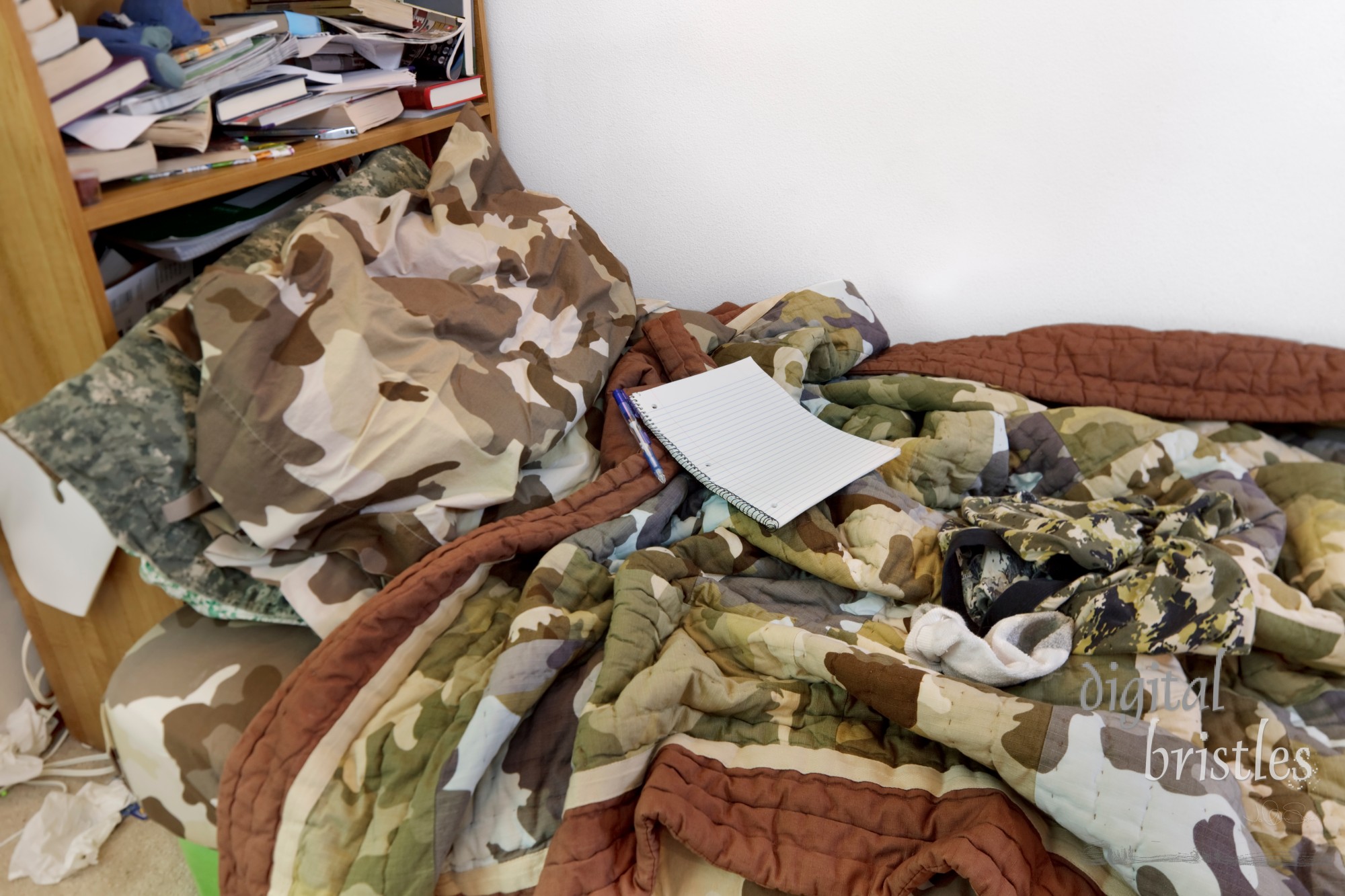 Teenage boy's messy bed with notebook, dirty sock, underwear... Tilt-shift lens; focus on notebook