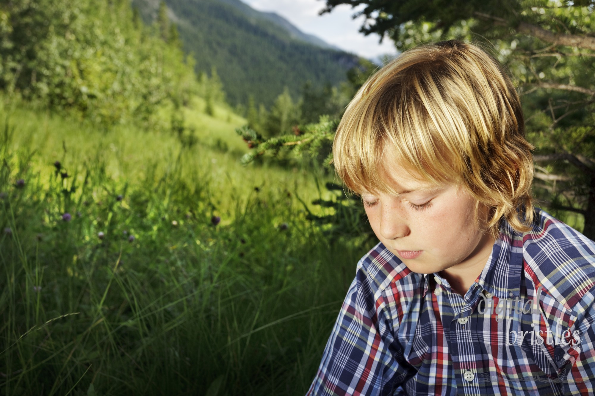 Young boy pensive and downcast in the tall grass