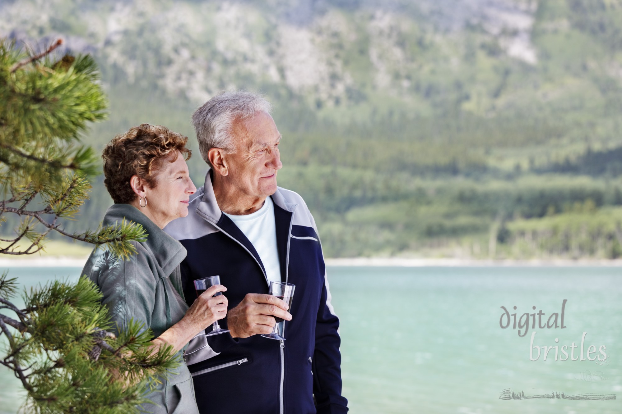 Senior couple enjoying a glass of wine as they look out over the lake