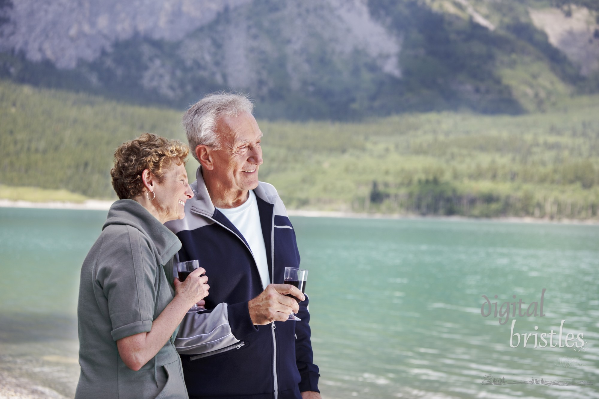 Senior couple shares a glass of wine by the lake