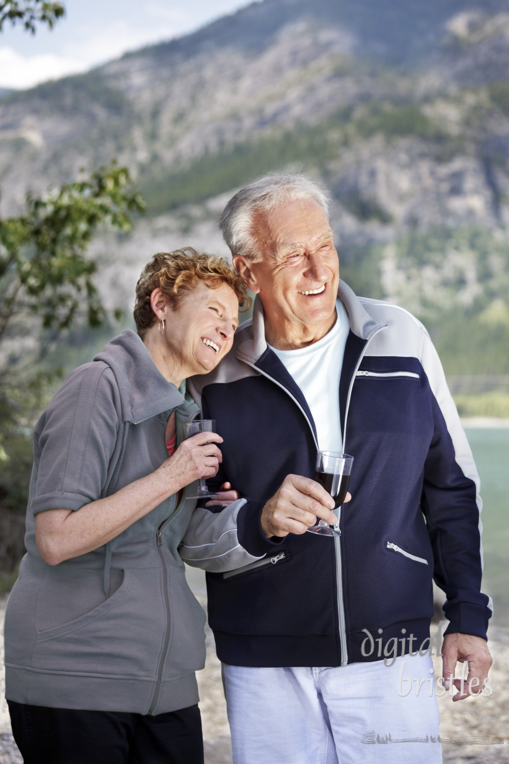 Senior couple shares a glass of wine by the lake