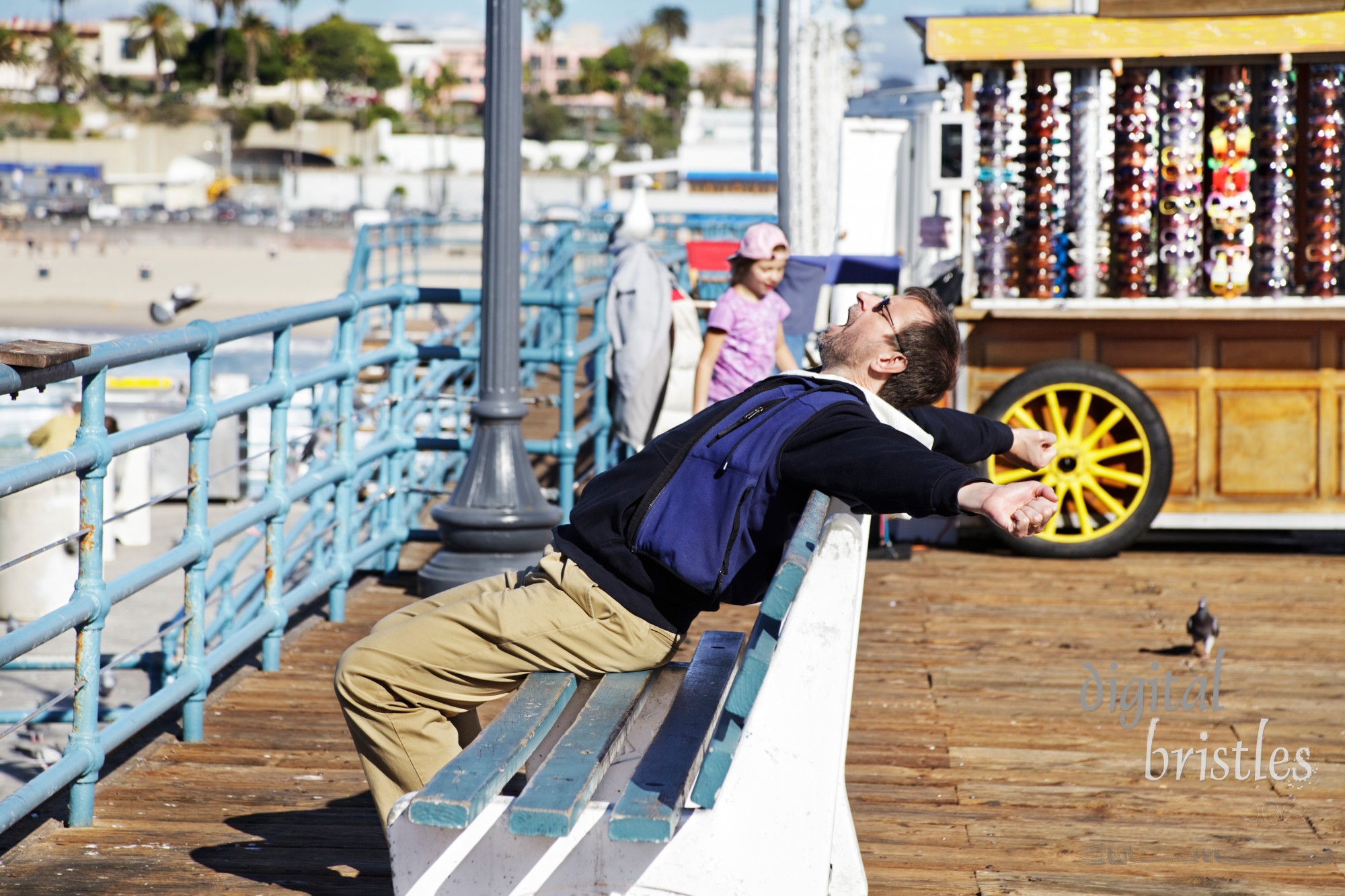 Man stretches after resting in the winter sun on Santa Monica pier