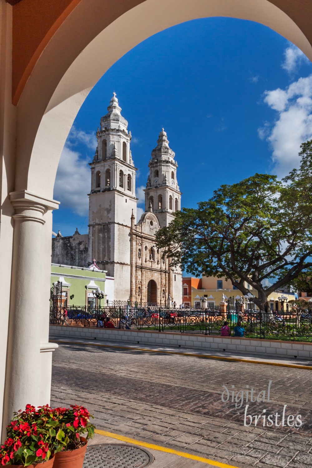 Towers of Campeche cathedral as seen from across the square under an arched colonnade