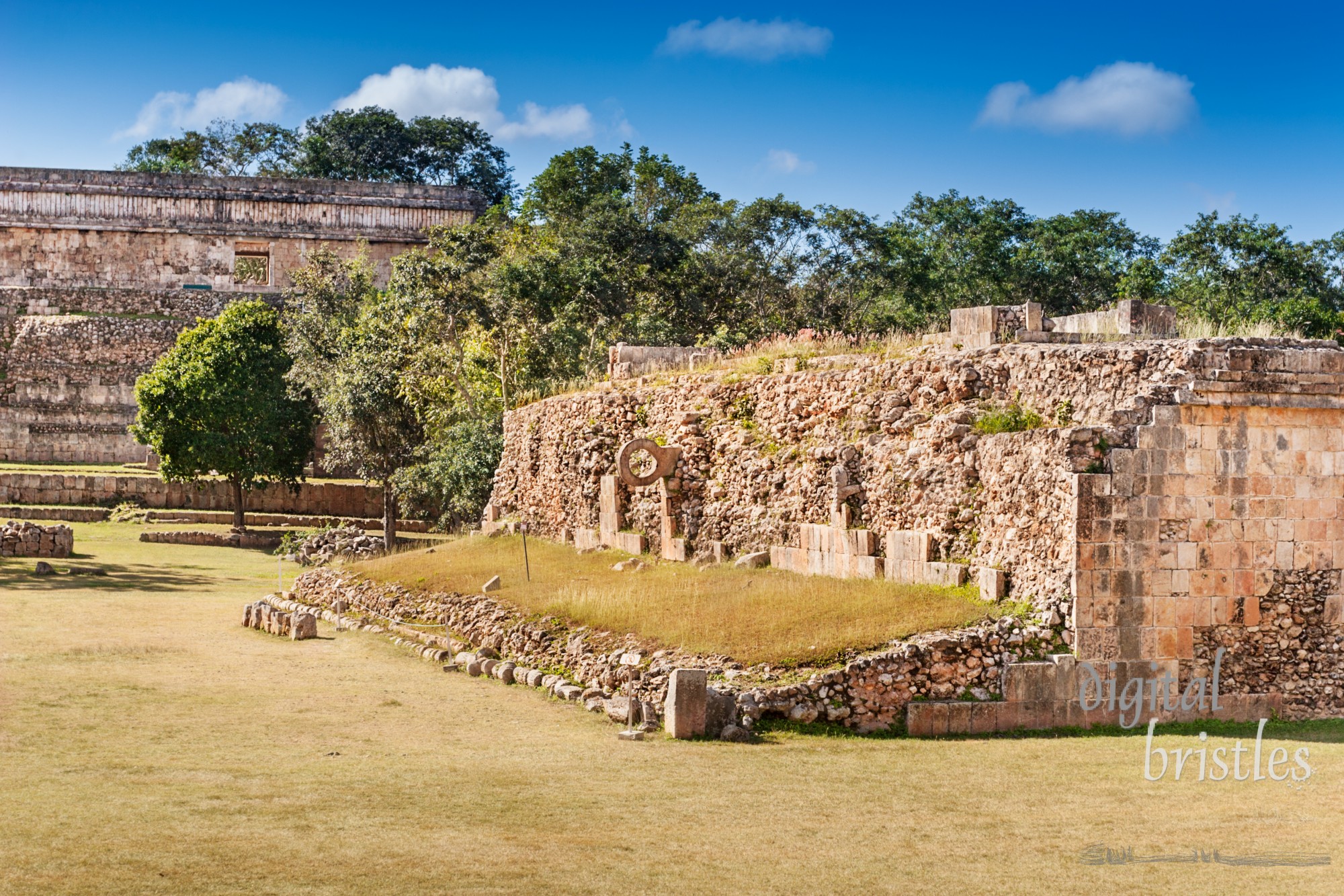 Partially restored Grandstand in the Ball Court, Uxmal showing the ballring. House of the Turtles in the background