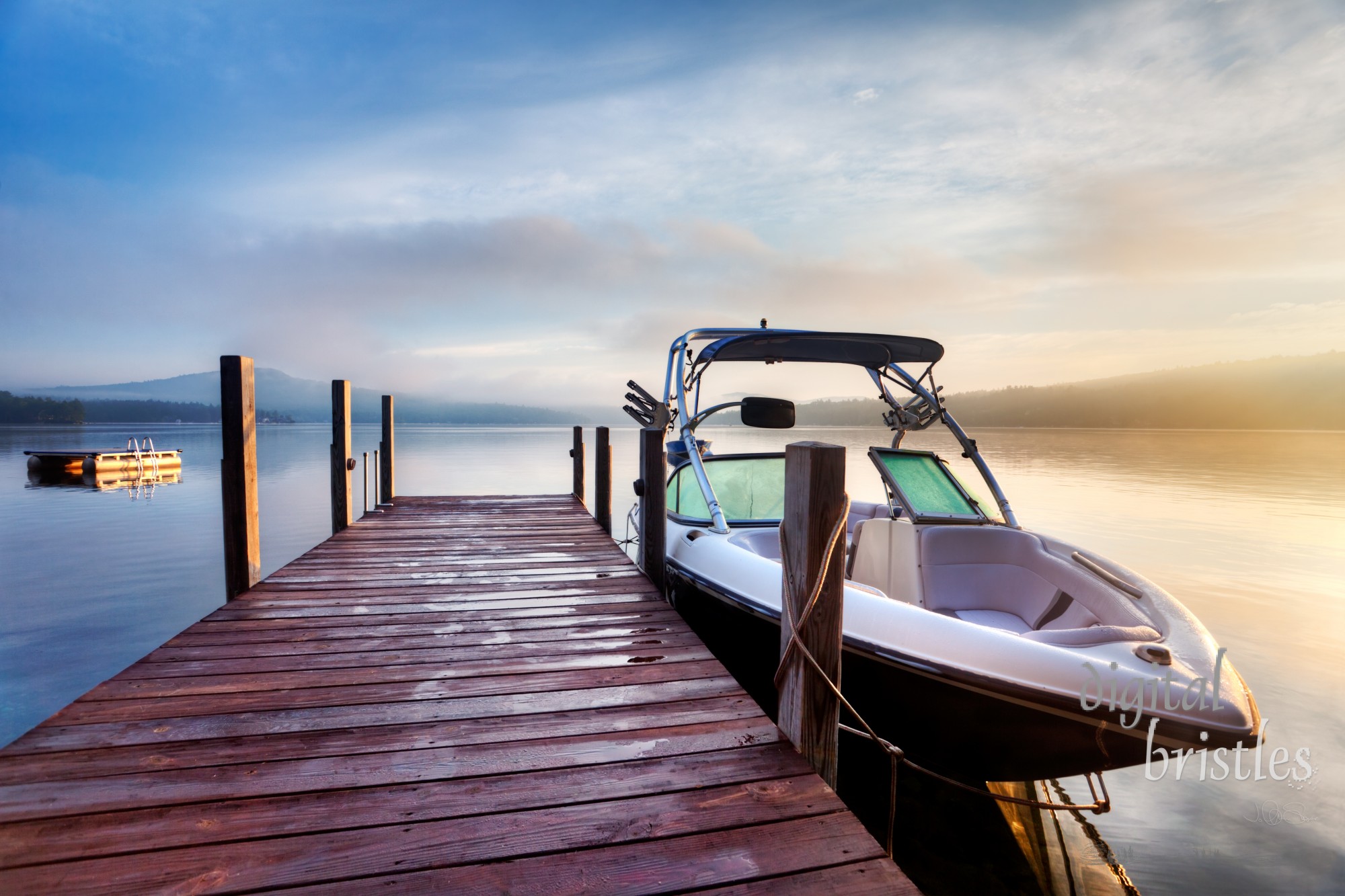 Sun and mist on a Summer New Hampshire boat dock at sunrise