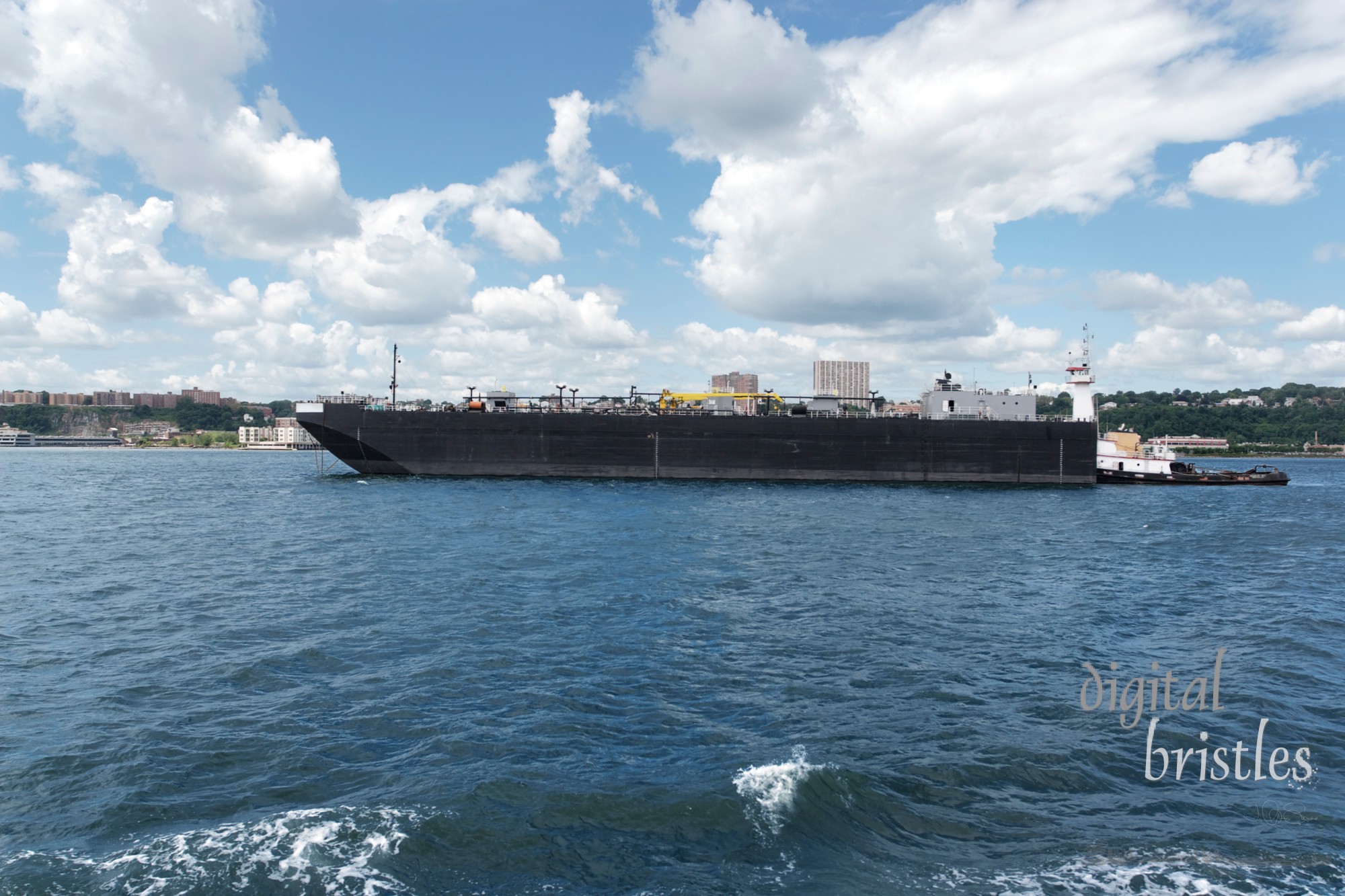 Tug boat shoves a larger boat down the Hudson River, New York