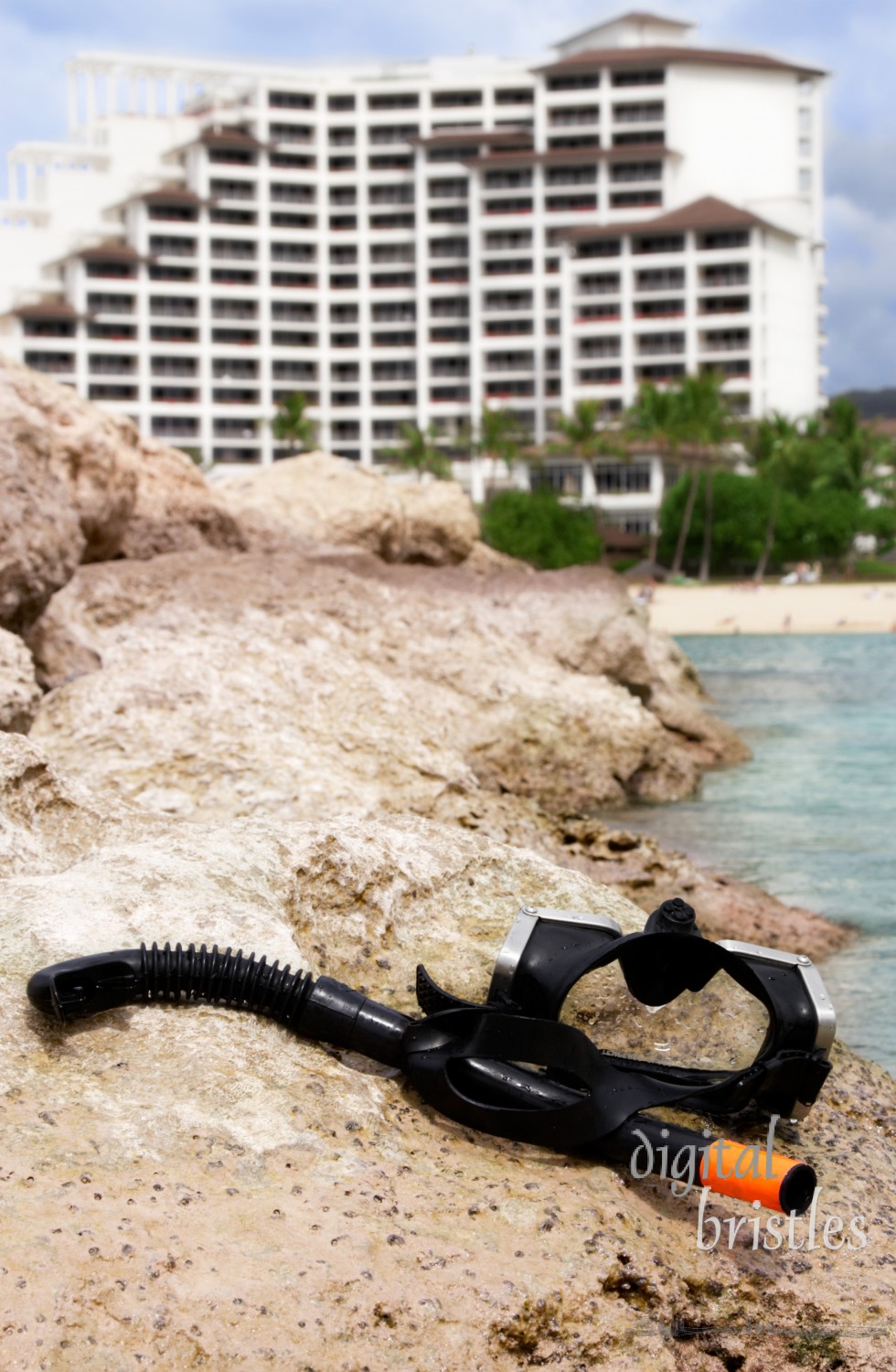 Mask and snorkel on the rocks, resort in background