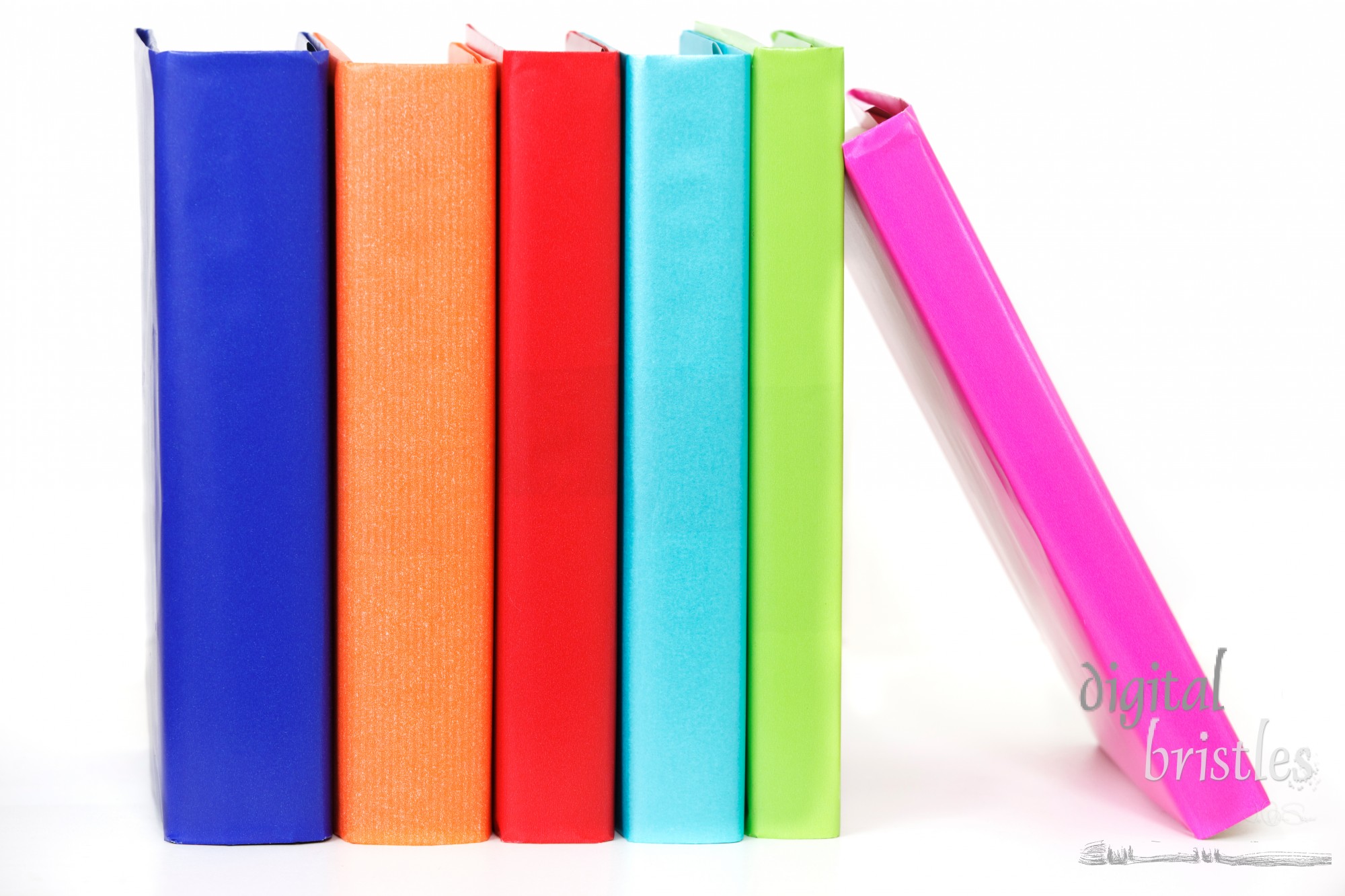 Row of colorful books proped up by one leaning on the end