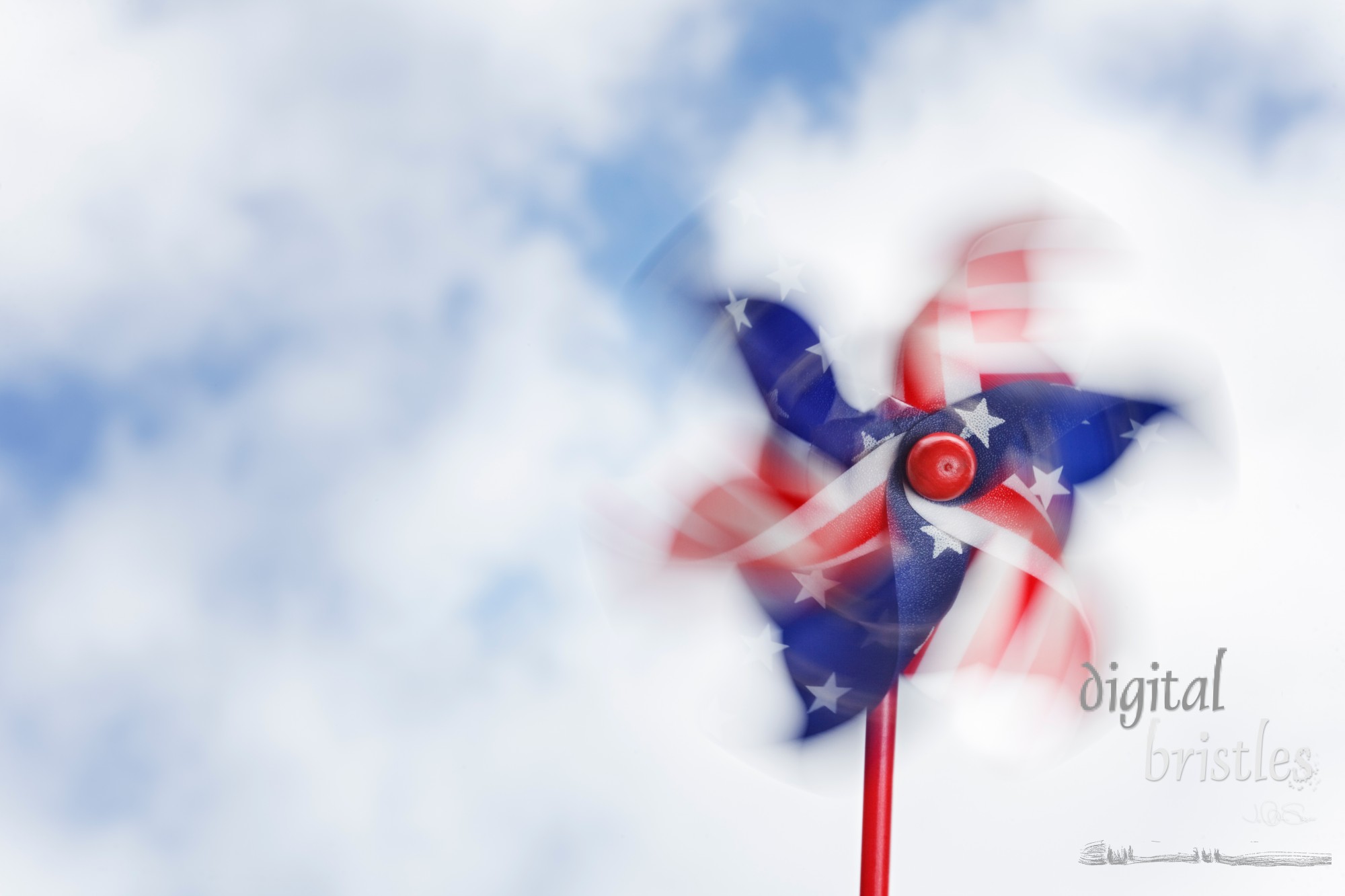 Red, white and blue stars & stripes pinwheel, spinning against a blue sky