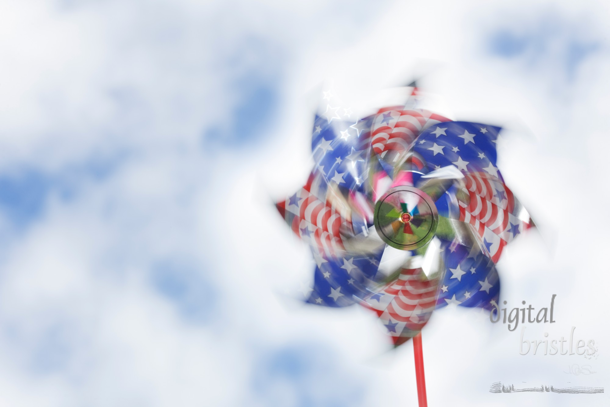 Shiny stars & stripes pinwheel spinning against a summery sky