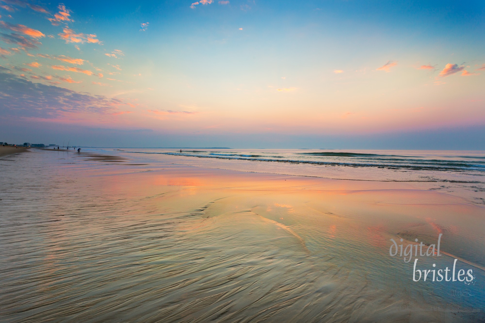 The sky grows vivid and clouds are reflected in the shapes of wet sand