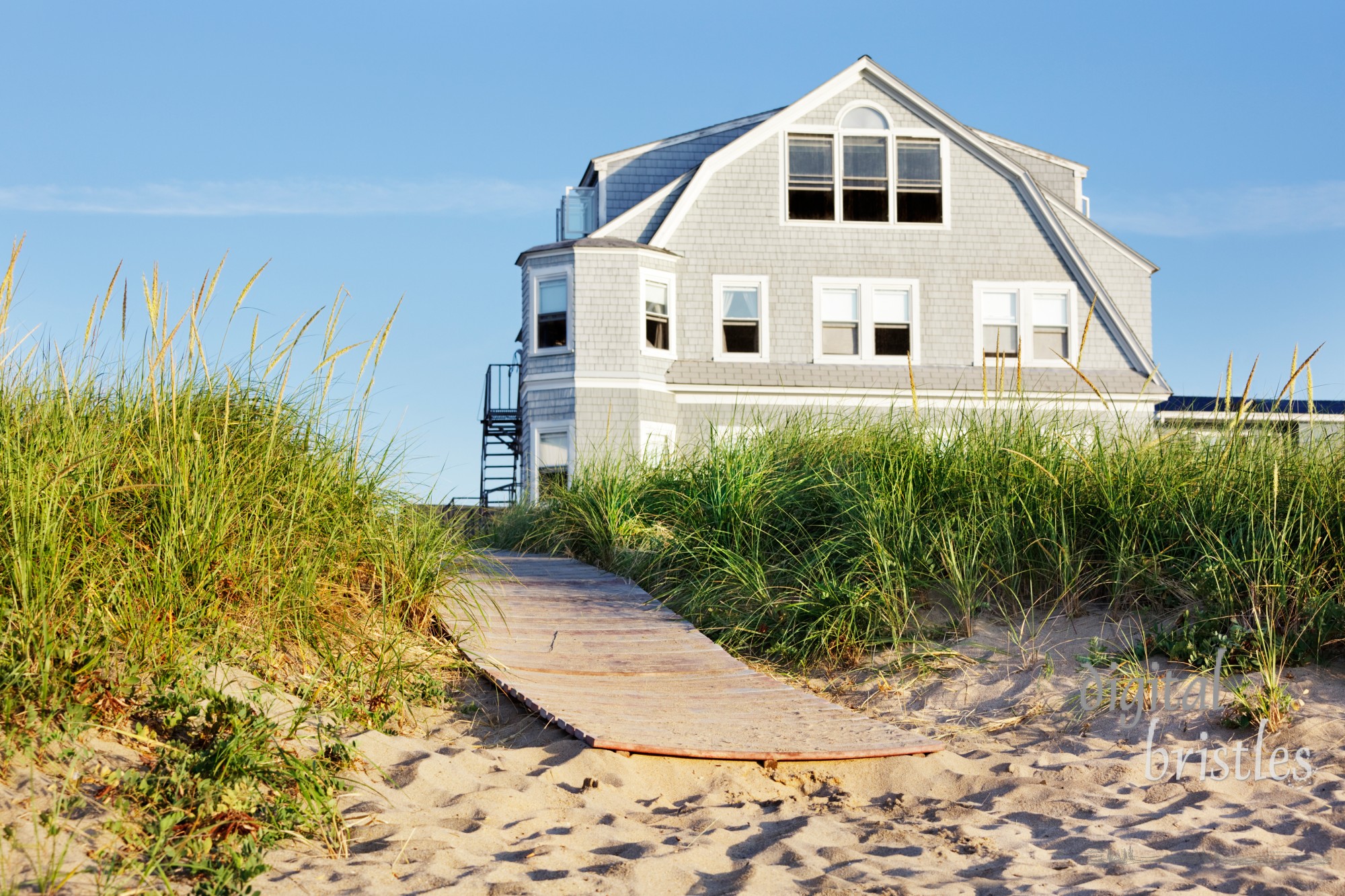 New England beach house by the boardwalk in early morning sun