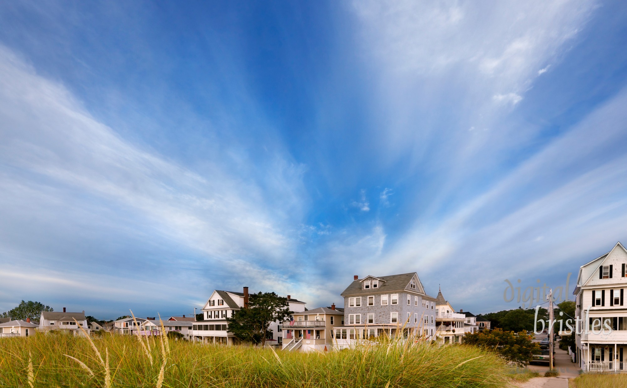 Dramatic morning clouds behind beach houses lining the dunes