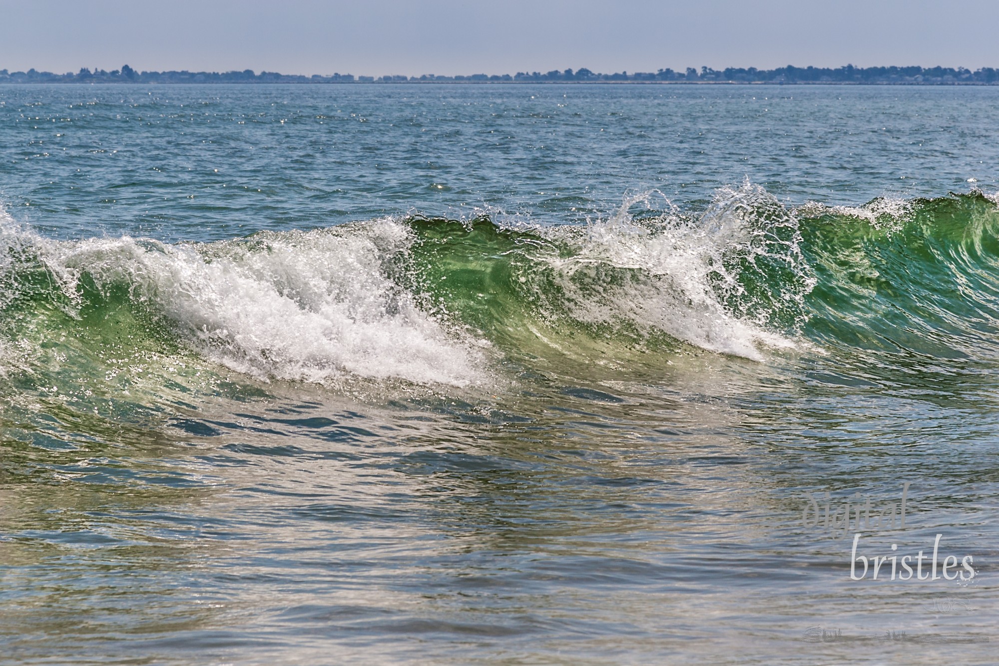 Gentle summer waves on the beach at Ocean Park, Maine, sparkle in bright sunlight