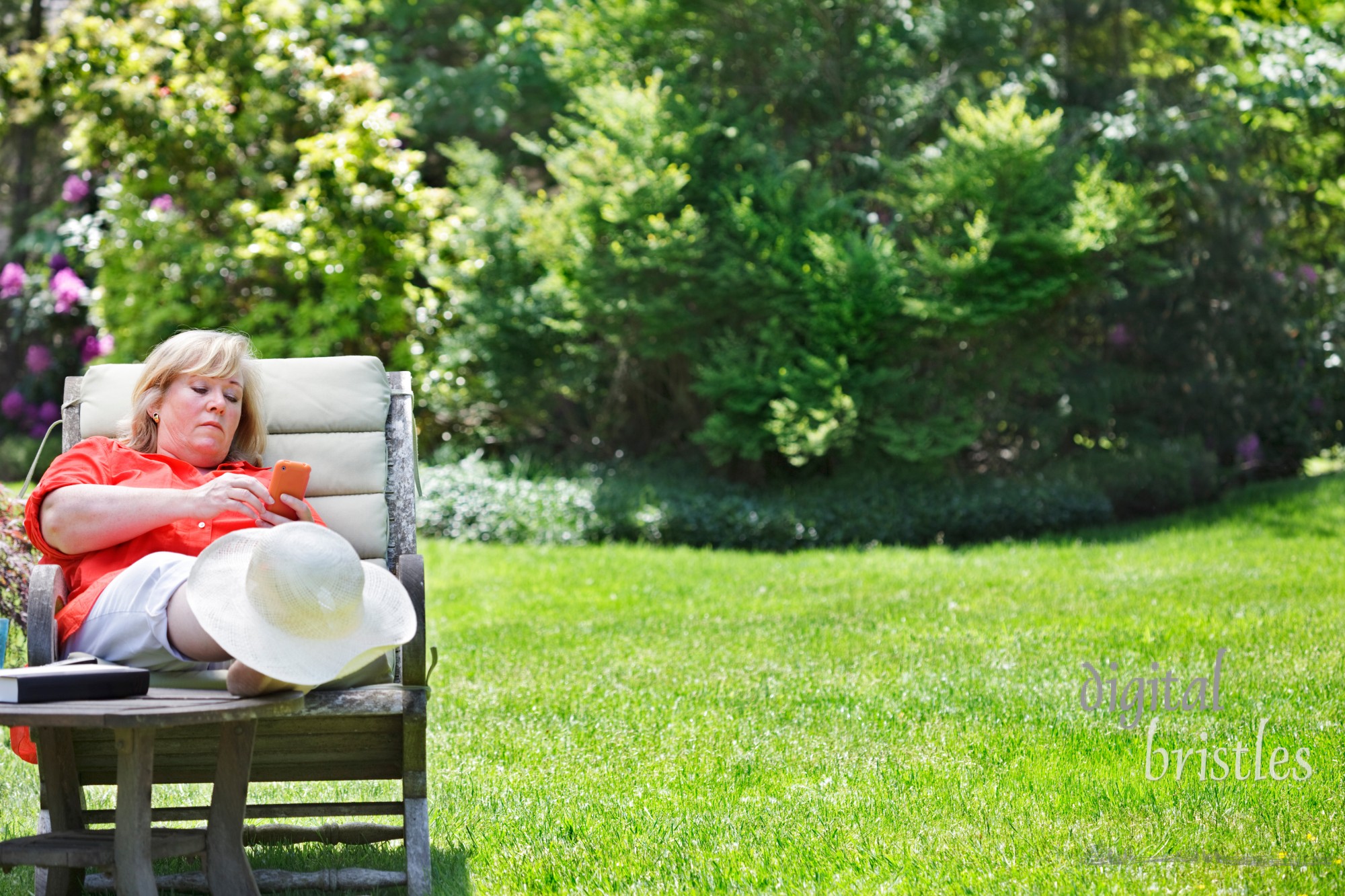 Mature woman using PDA while enjoying the Spring sunshine