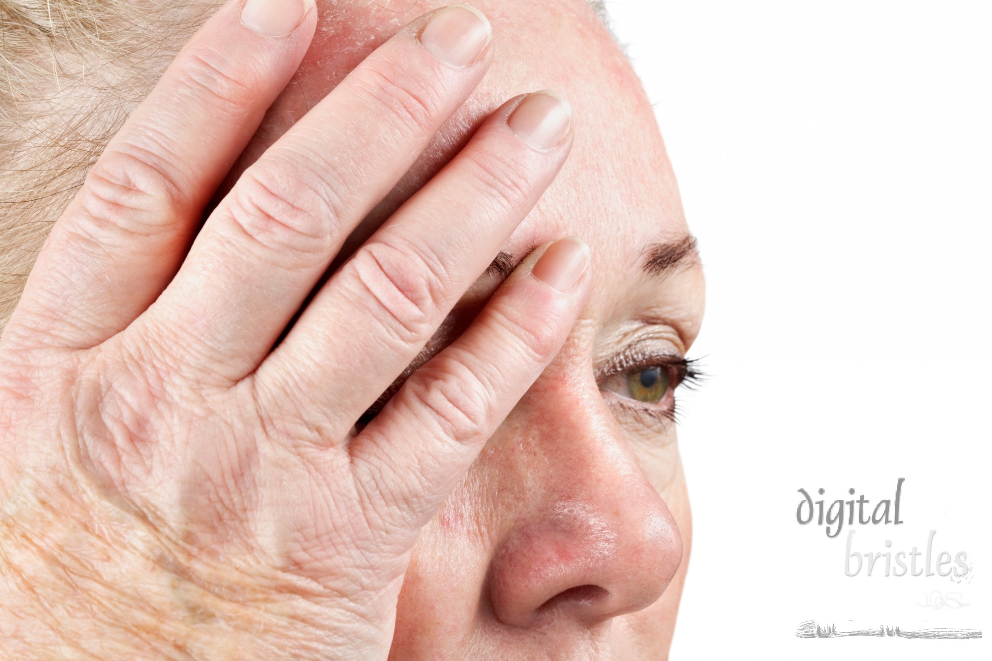 Mature woman holds her head in pain. Focus on fingers.