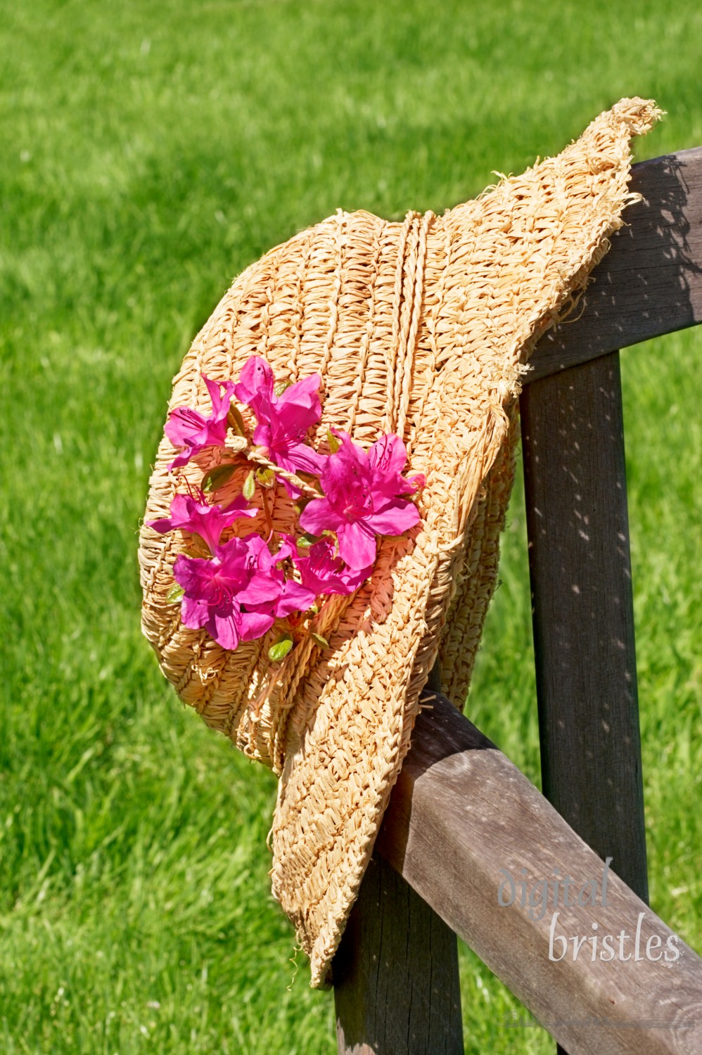 Crushable straw hat hanging over a chair in a sunny spring garden