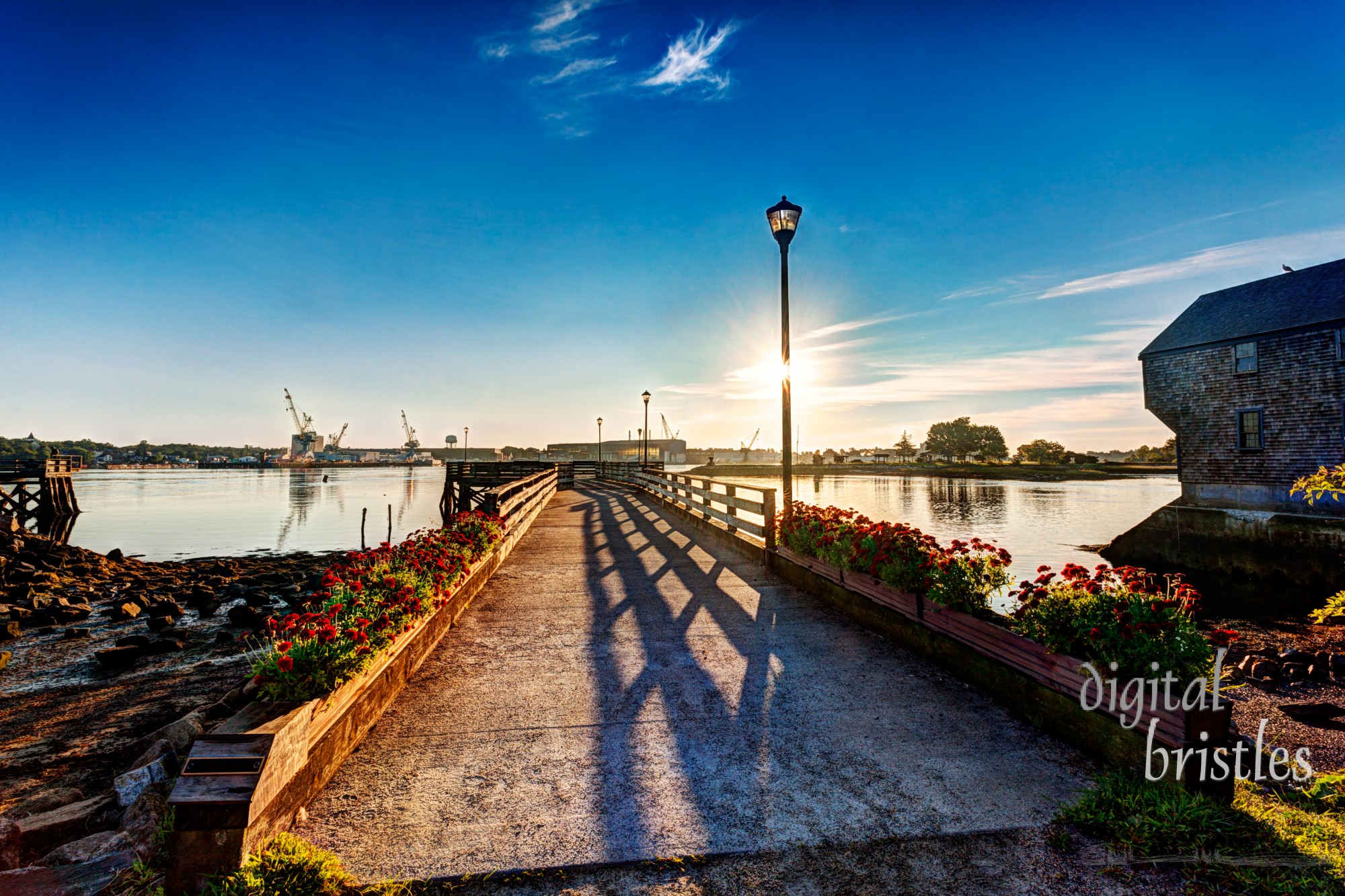 Sun rises over the Piscataqua River and the Portsmouth Navy Yard as seen from Prescott Park, Portsmouth, NH