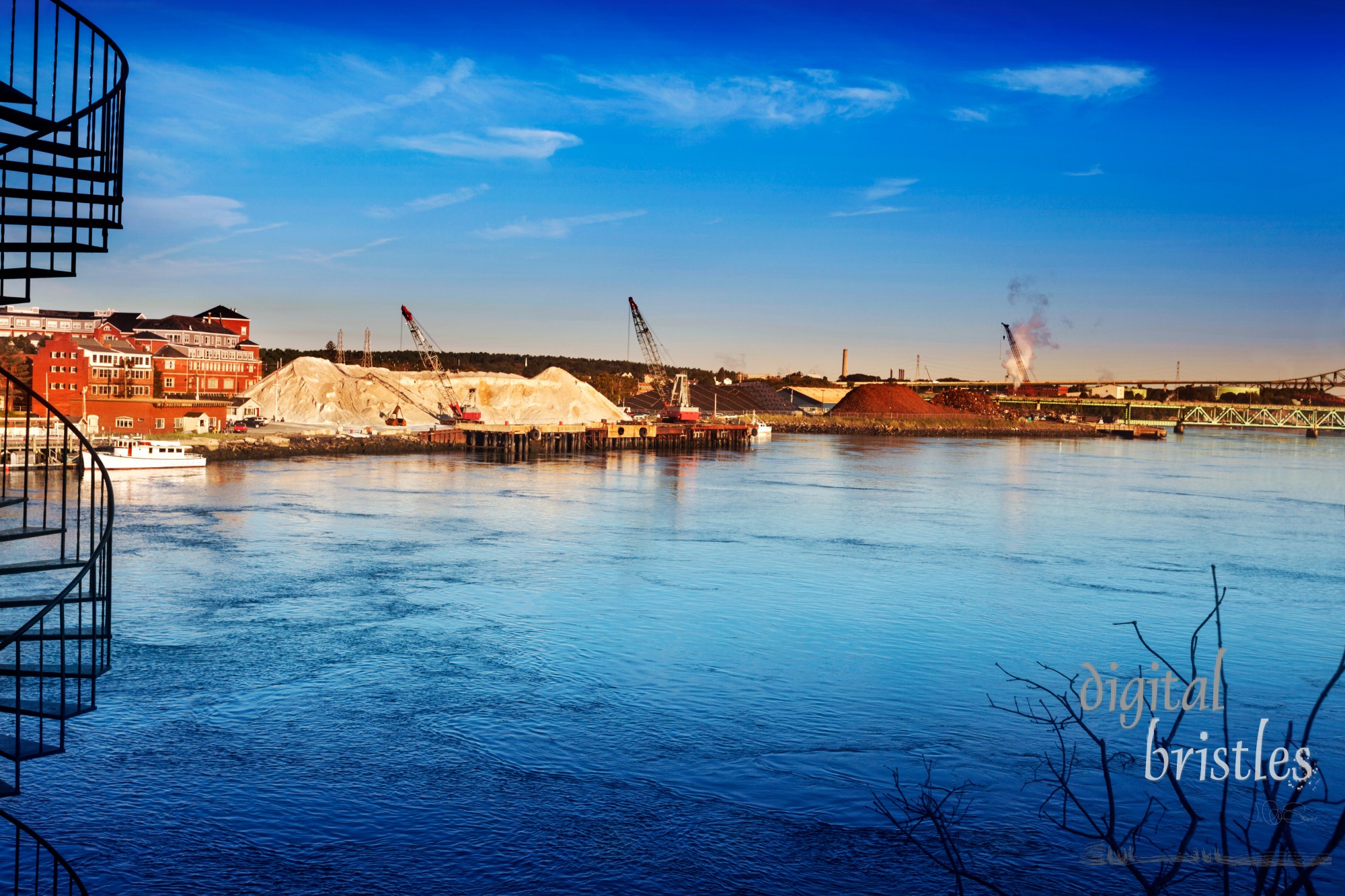 The massive salt piles at Granite State Minerals lit by the morning sun over the Piscataqua River, Portsmouth New Hampshire. The Piscataqua currents are in the US top 40 fastest, creating swirls and patterns in the river surface