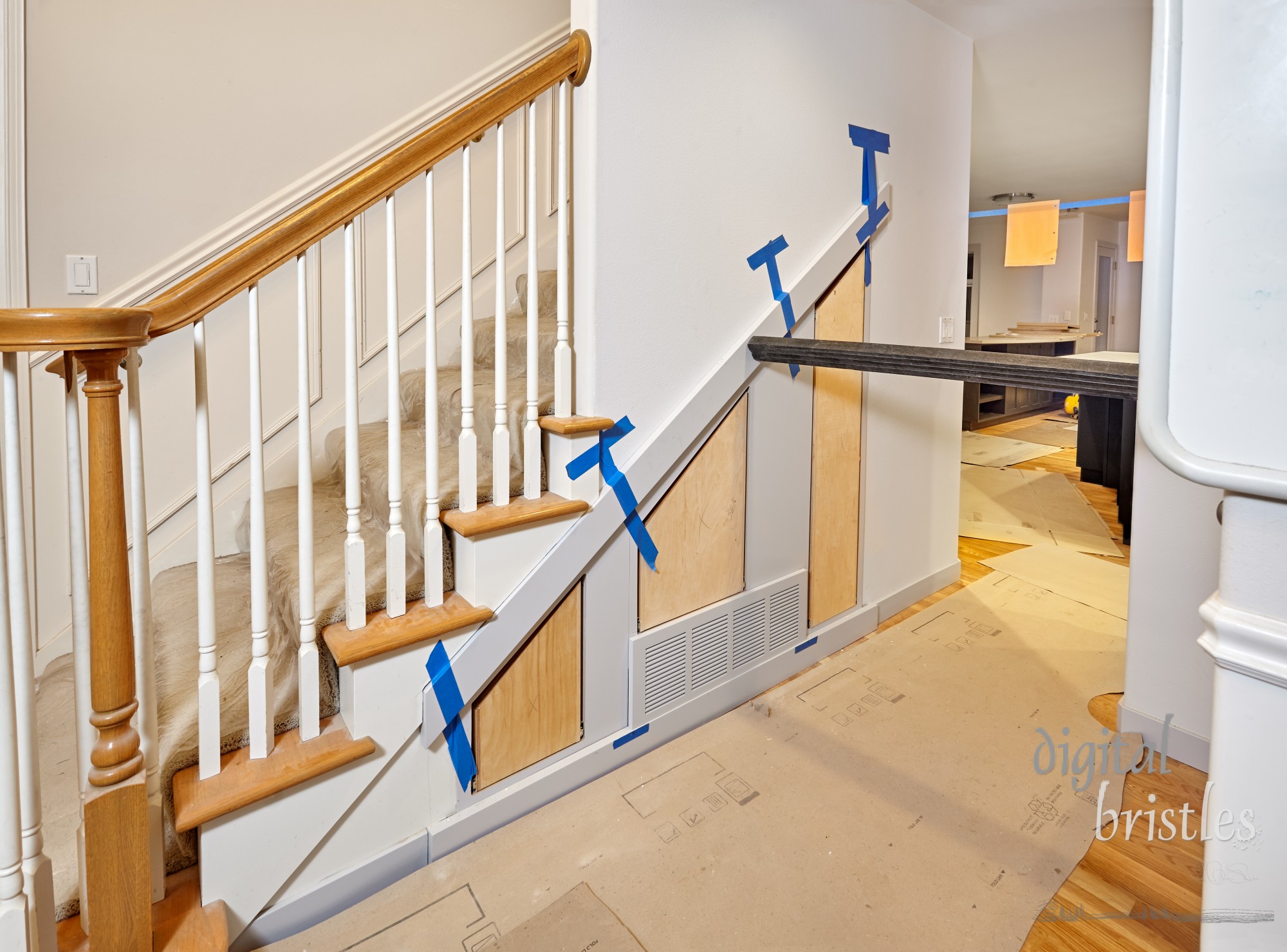 Trim surrounding custom built pullout cabinets under stairs held in place while glue dries