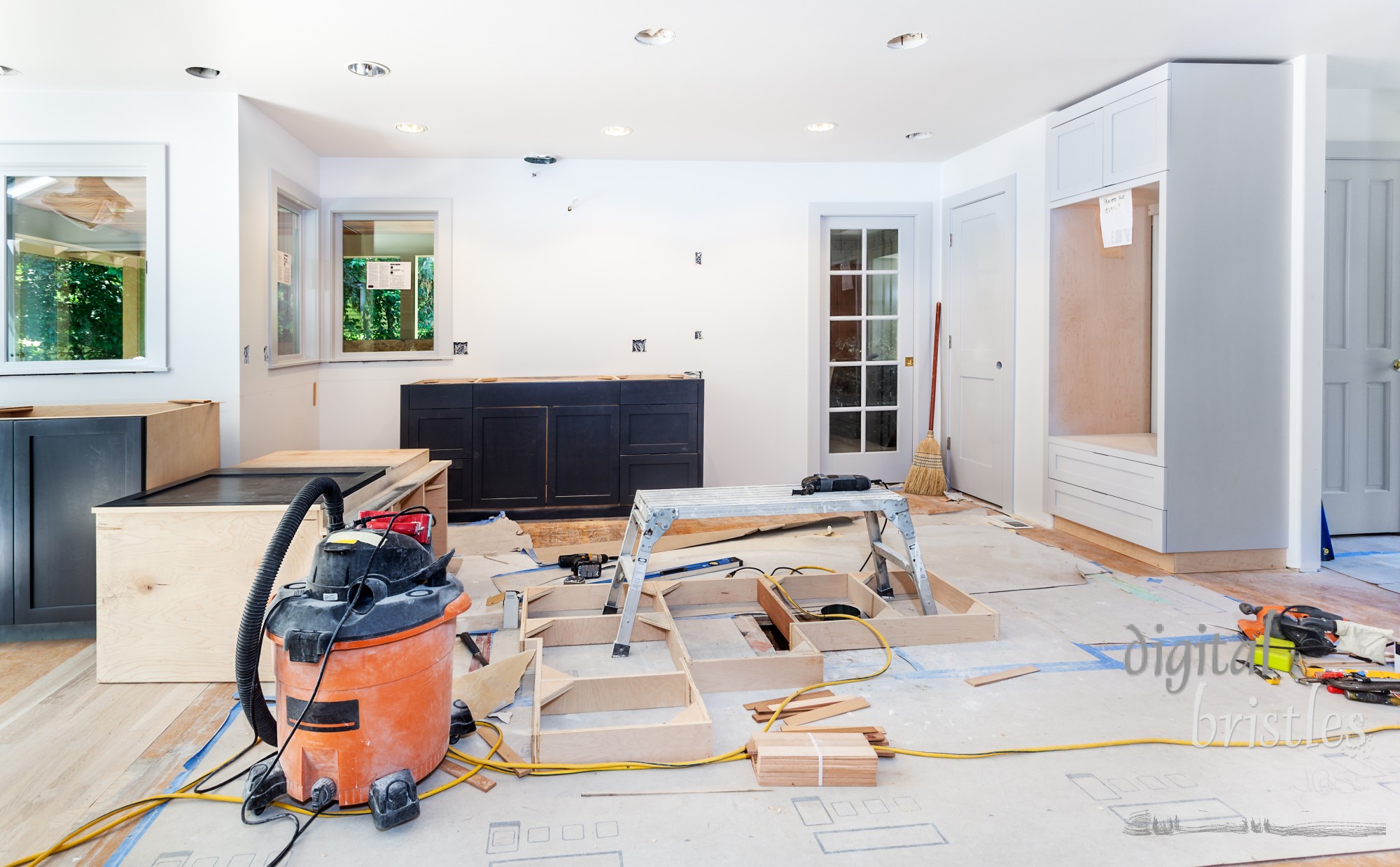 Custom kitchen cabinets in various stages of installation; base for island in center