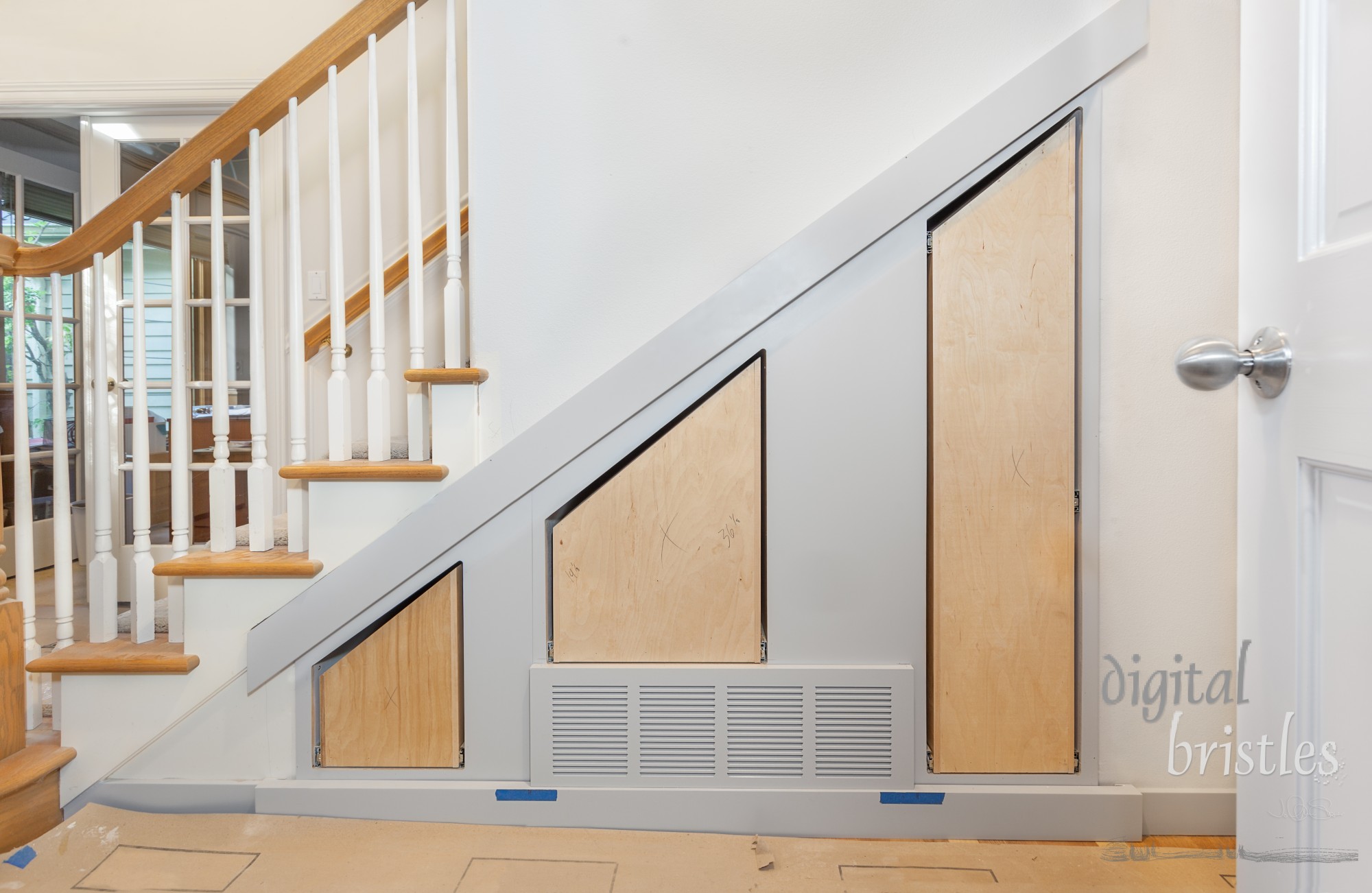 Custom built pullout cabinets on glides in slots under stairs