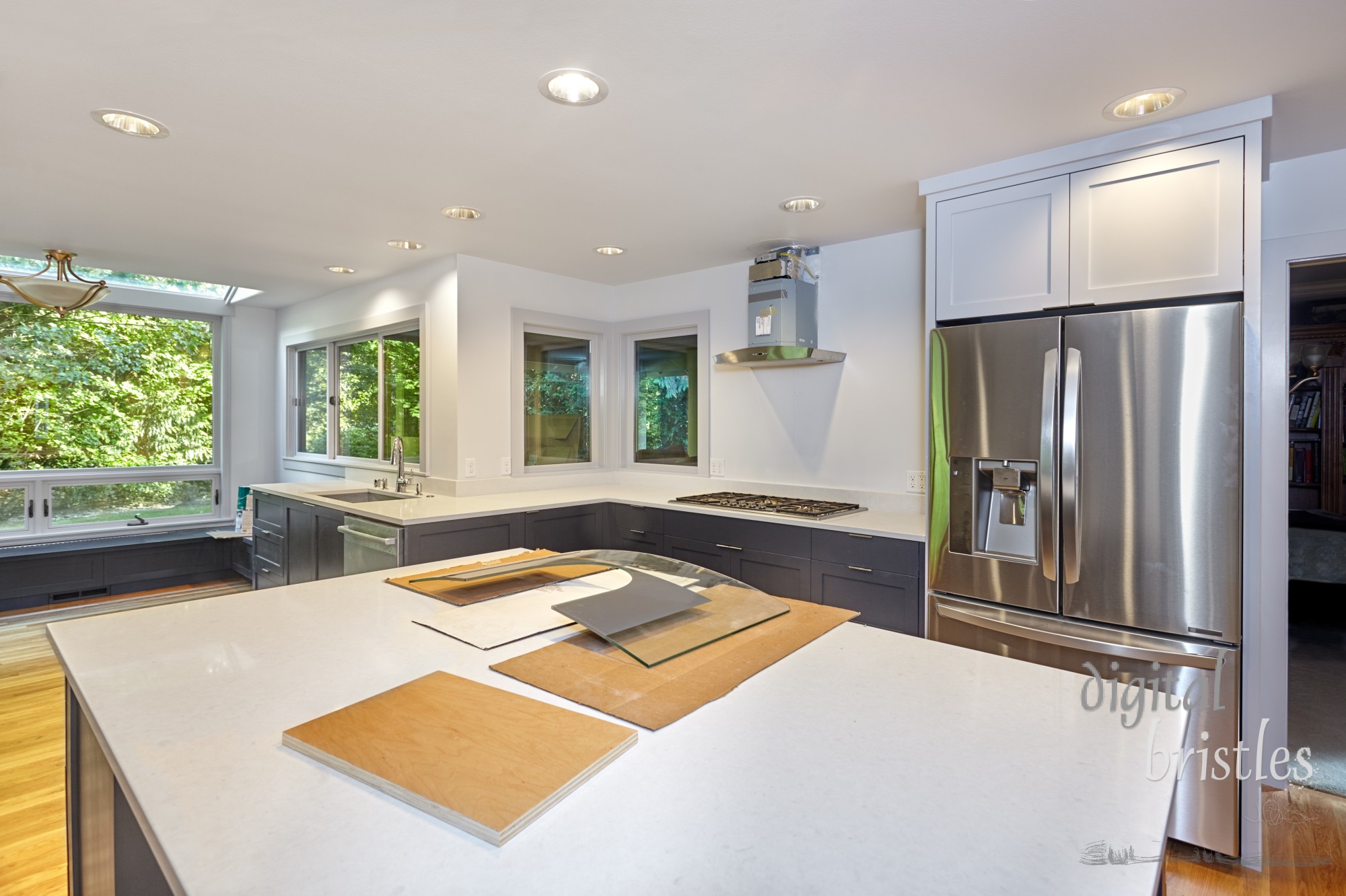 Kitchen range hood and glass cover being installed as work nears completion