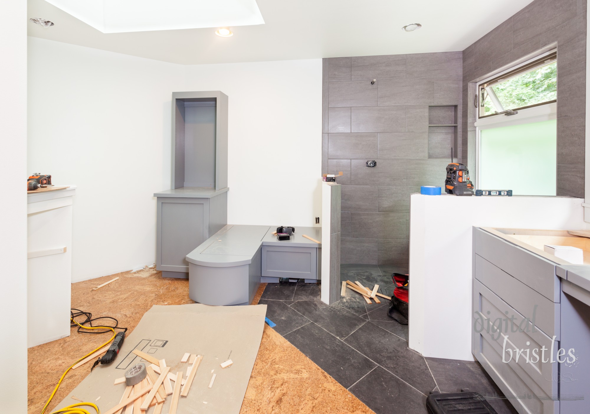 Custom cabinets being screwed into place in master bathroom