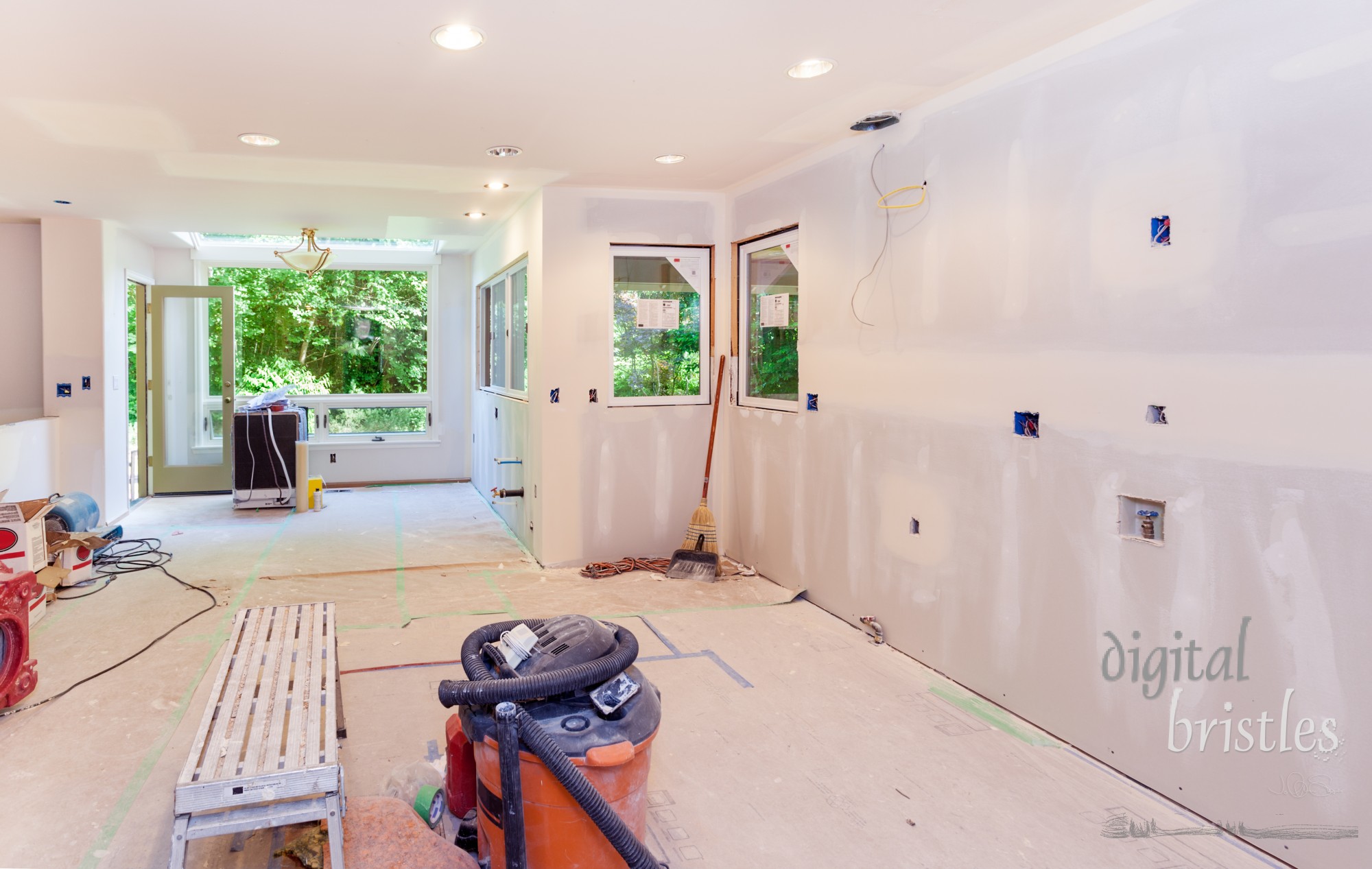 Kitchen drywall taped and mud applied to seams. Windows in place and debris cleaned up at the end of the work day