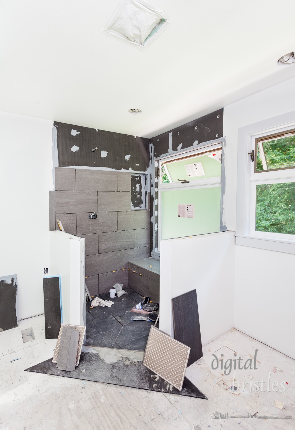 Tile installation underway in the shower area, partially covering the waterproofing board underneath