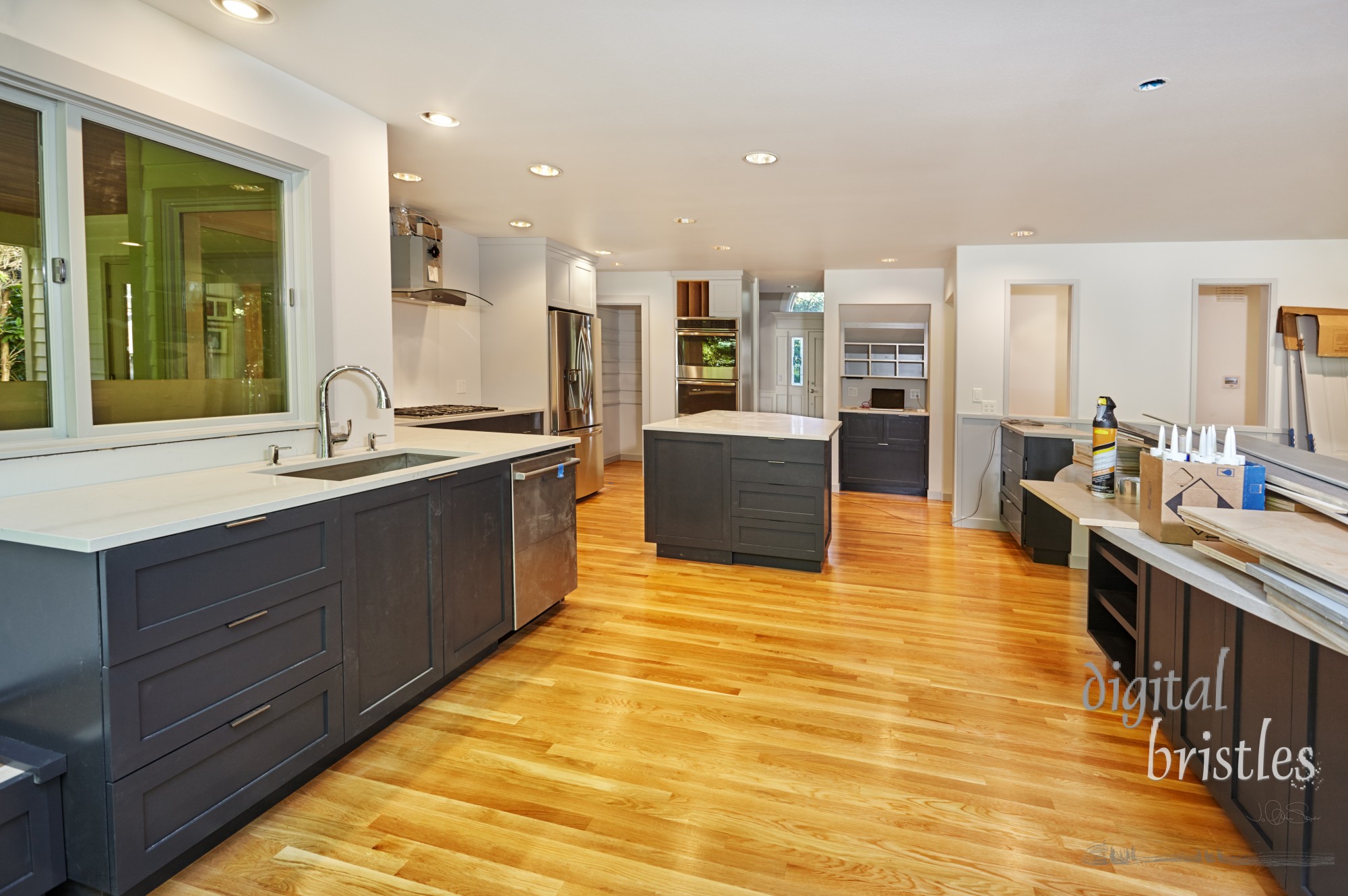 Cardboard floor covering removed in kitchen as doors and final trim installation await