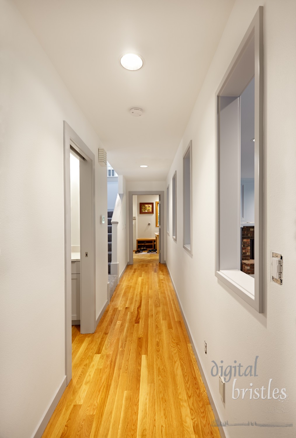 Hallway hardwood floor patched and refinished; openings to family room add natural light