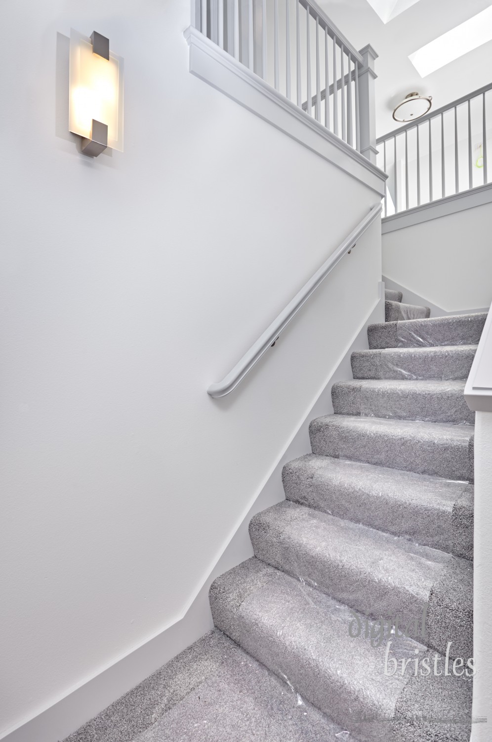 Newly installed stair carpet covered with protective plastic while remodeling work continues