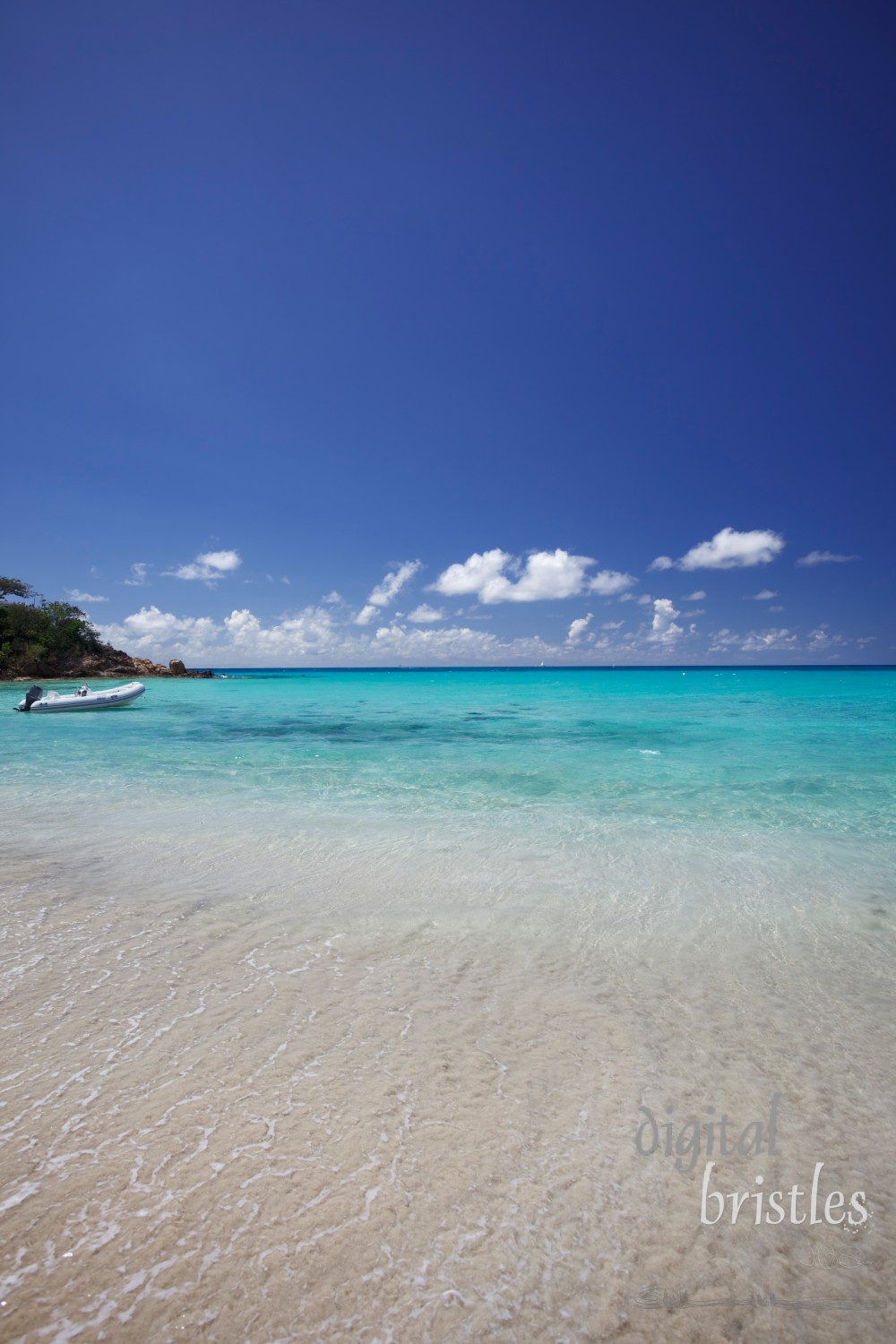 Dinghy with outboard motor anchored in a tropical bay