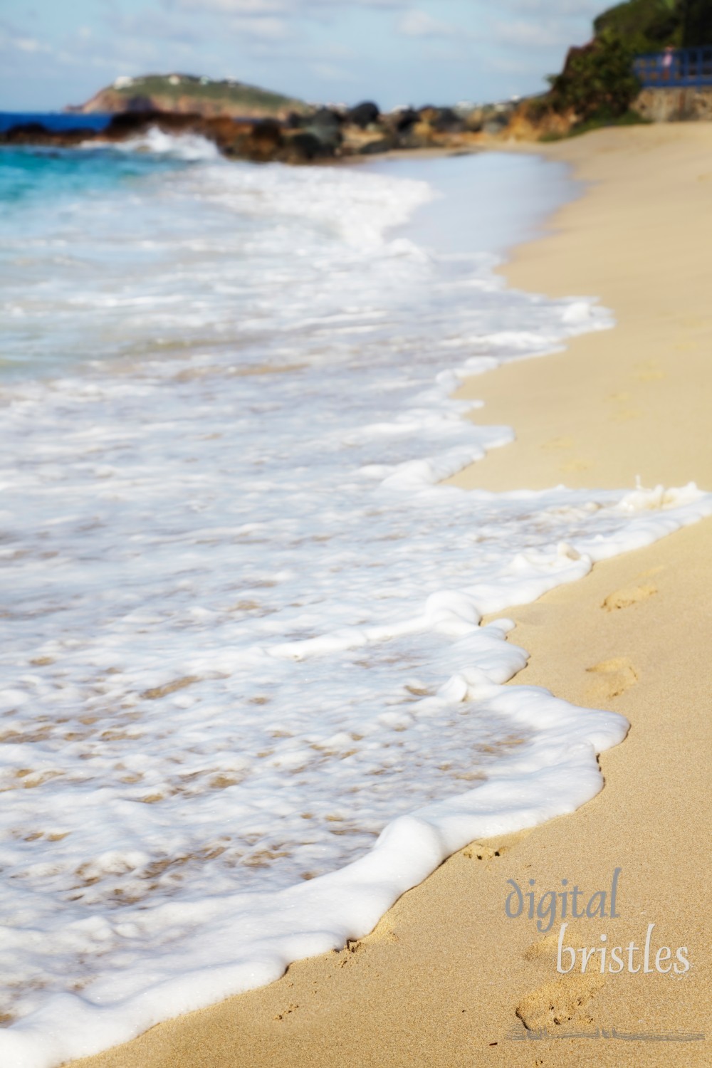 Waves washing away footprints in the sand