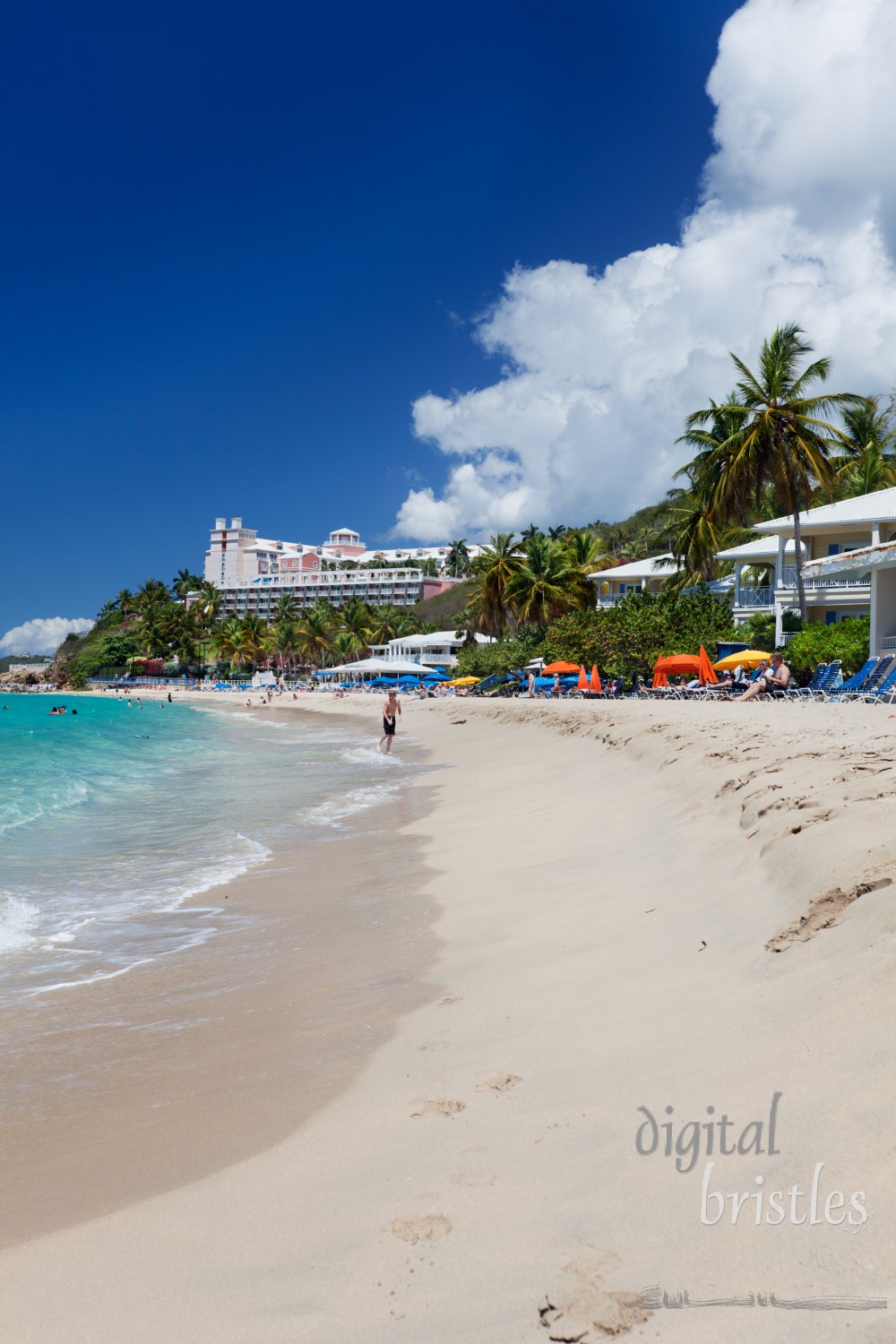 Swimmers and sunbathers on Morningstar Beach, looking towards Frenchman's Reef Hotel on the bluff. Morningstar Beach is just outside busy Charlotte Amalie where cruise ships dock.