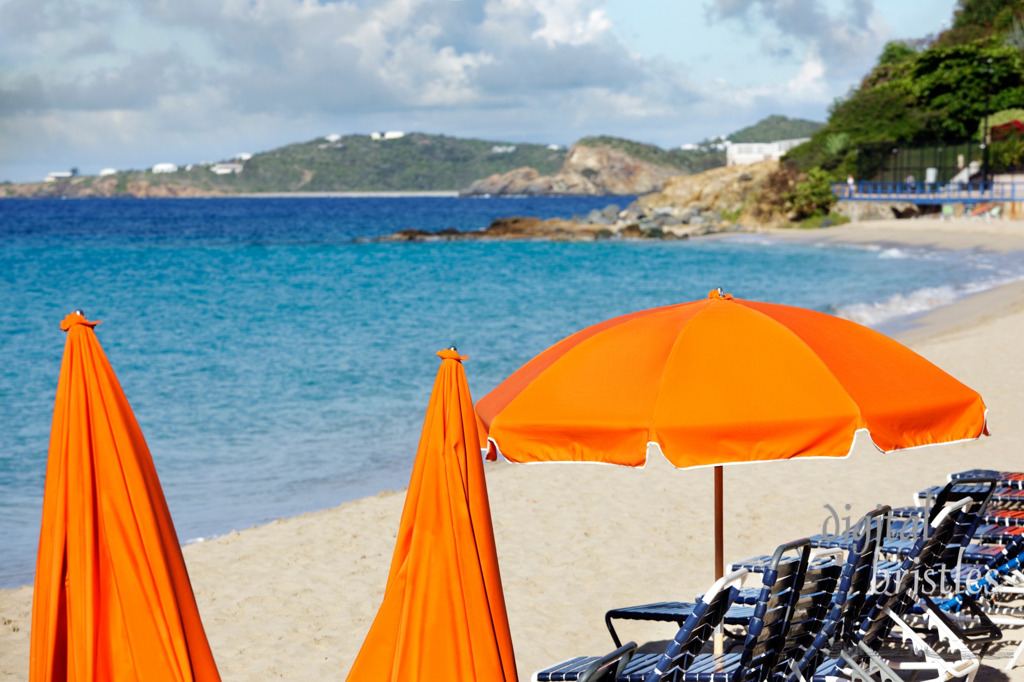 Bright orange beach umbrellas await the day's sunbathers